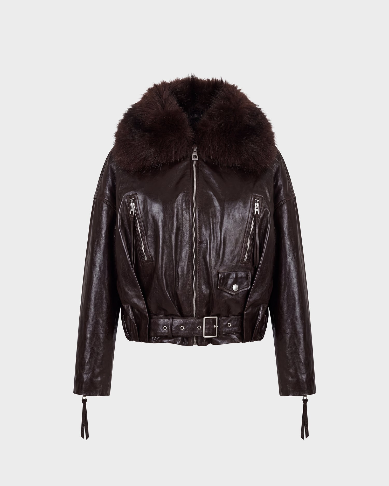 The AVITA - 8126938 Espresso by Rudsak is a dark brown leather jacket featuring a wide, fluffy fur collar, zippered pockets, a belted front with a buckle closure, and long sleeves with zippered cuffs. The jacket is showcased against a plain light background.