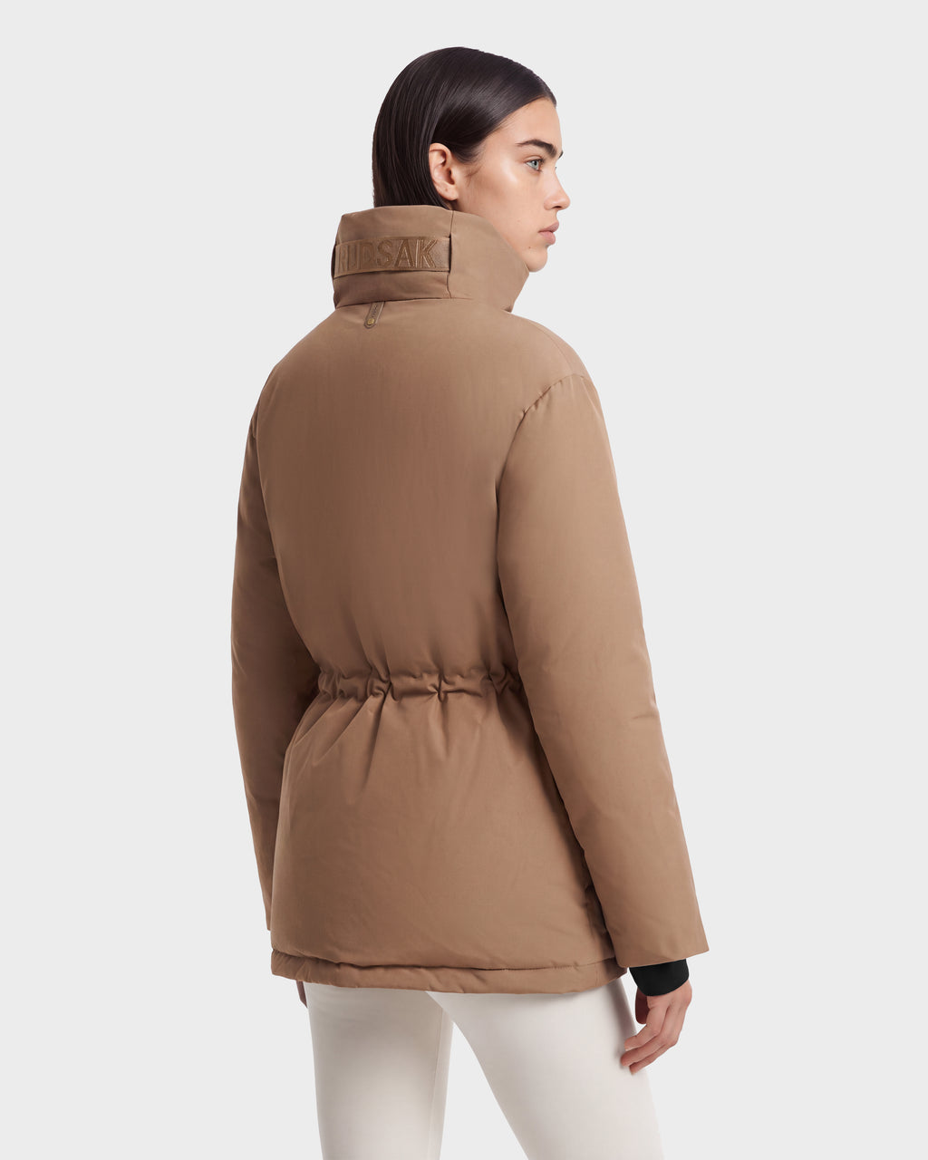 A camel-colored Rudsak BHIMA - 8126515 Camel RDS-certified down puffer jacket featuring a high collar and a cinched waist, ideal for extreme cold weather.