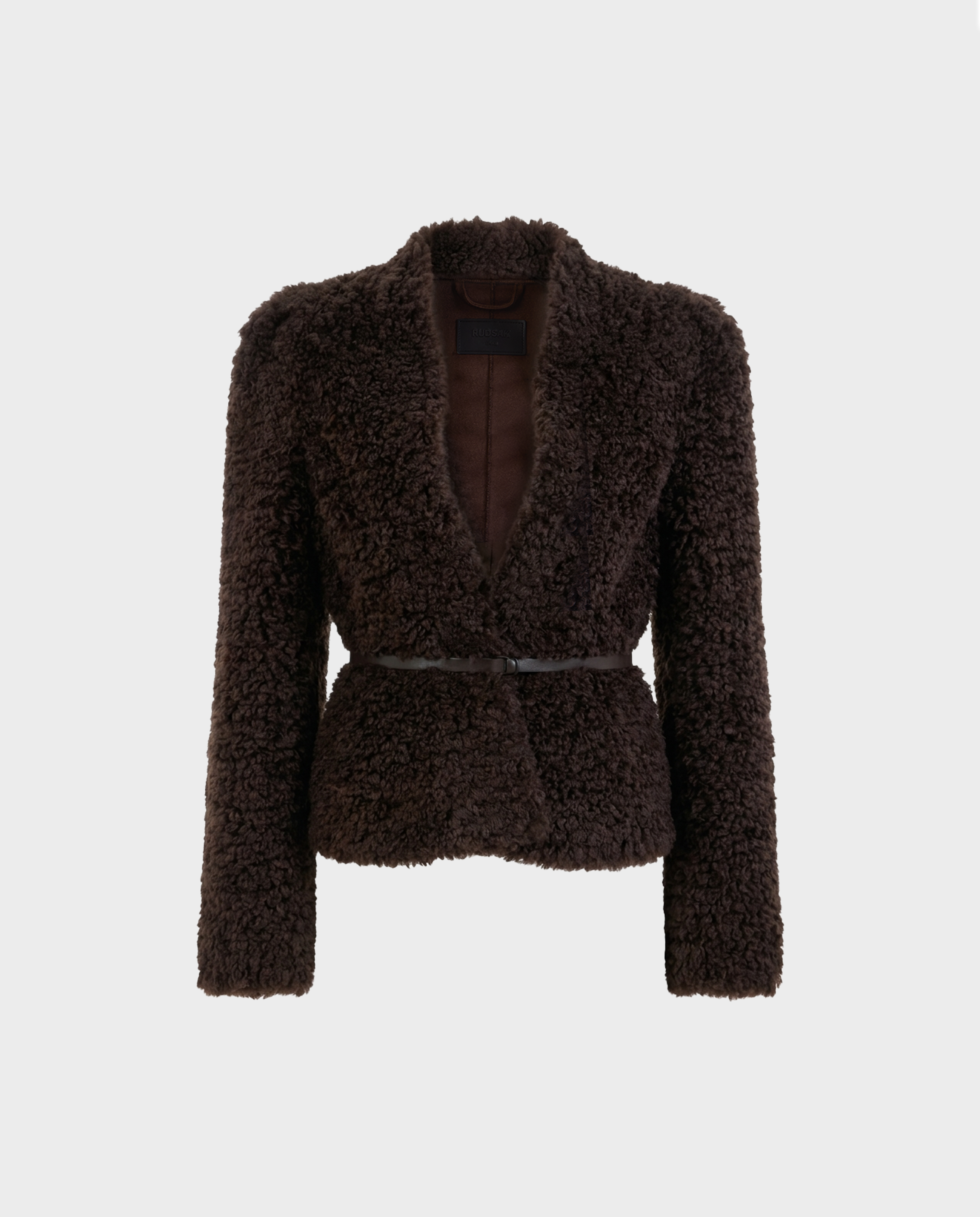 The BRINLEY - 8126980 Espresso by Rudsak features a dark brown, textured faux fur teddy blazer with long sleeves, an open front, and a thin black belt at the waist—perfect for transitional layering. Displayed against a plain white background.