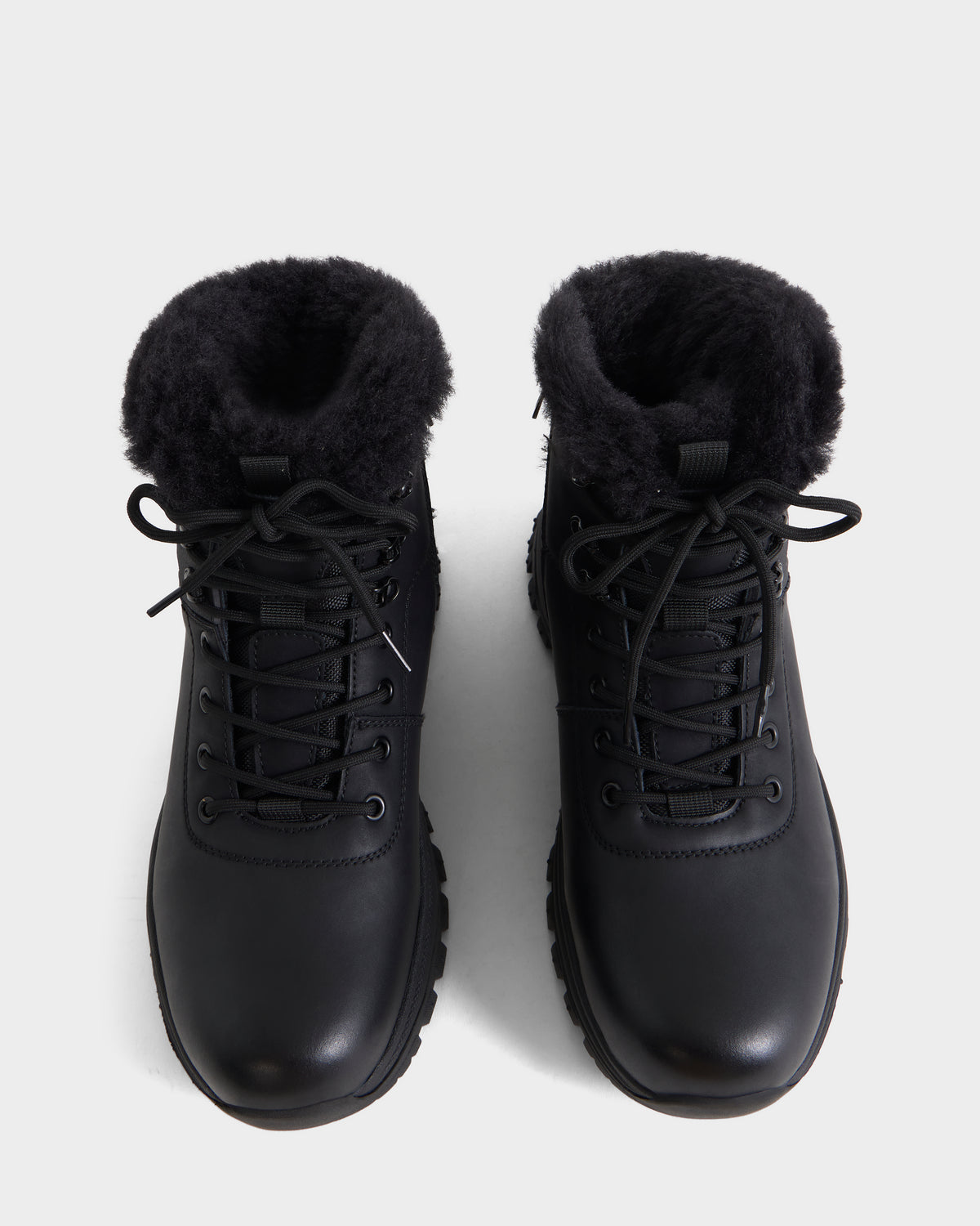 A top view of the Rudsak BRYSON - 6226504 Black winter boots, featuring a lace-up silhouette and plush black lining, showcased on a plain white background.