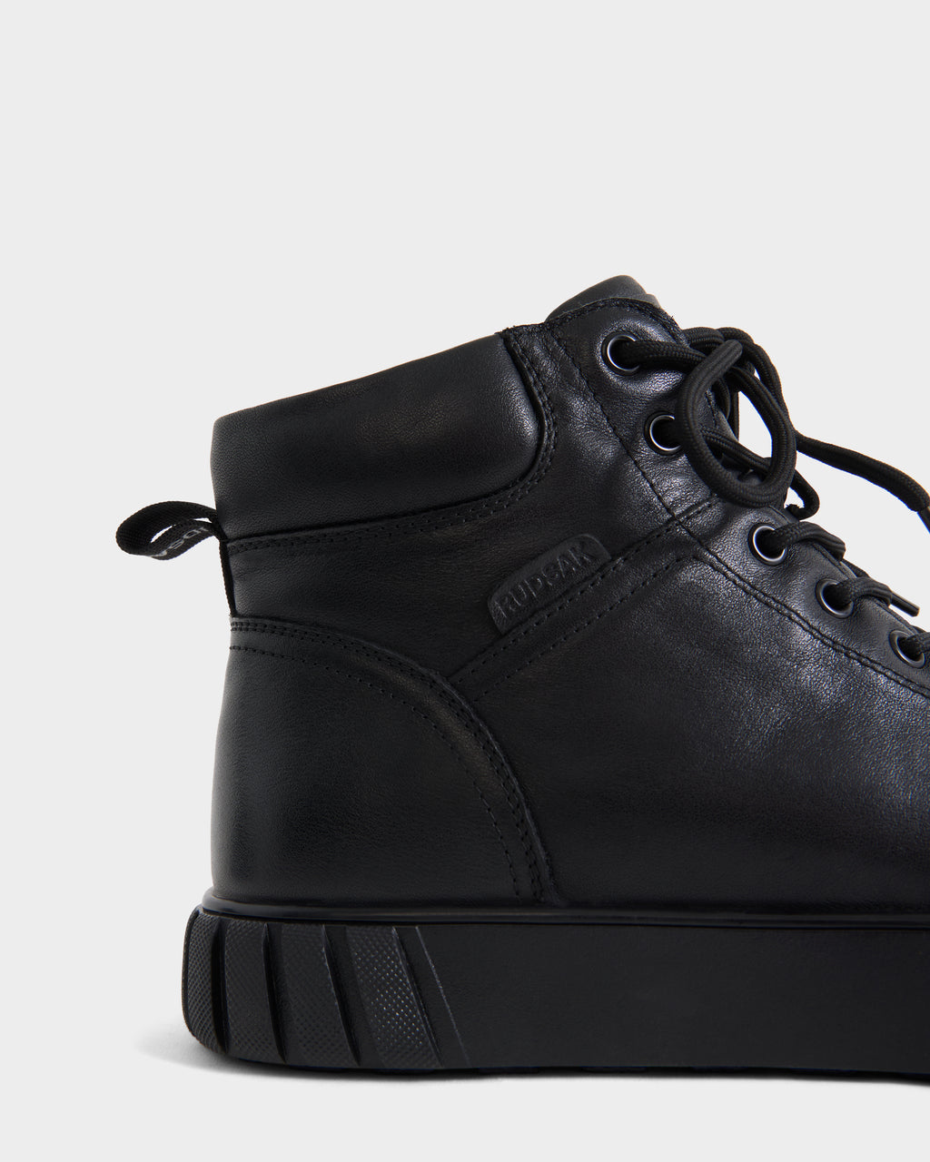 Close-up of Rudsak DAVE - 6226501 Black high-top boots featuring black leather, black laces, and a textured rubber sole.
