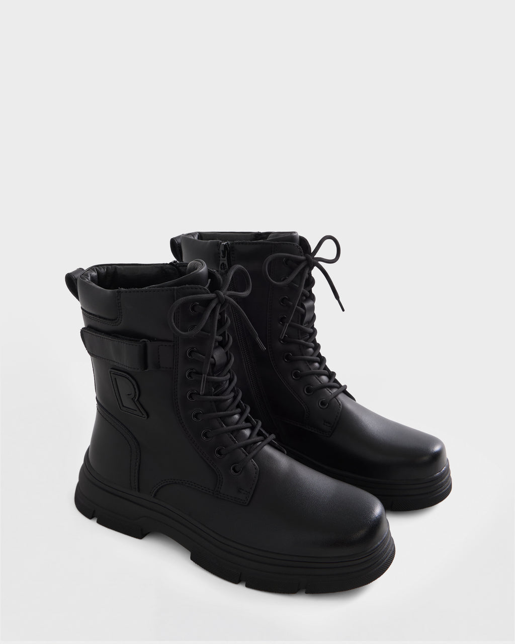 The DEREK - 6226506 Black combat boots by Rudsak feature thick soles, lace-up fronts, and side zippers, shown on a plain white background.