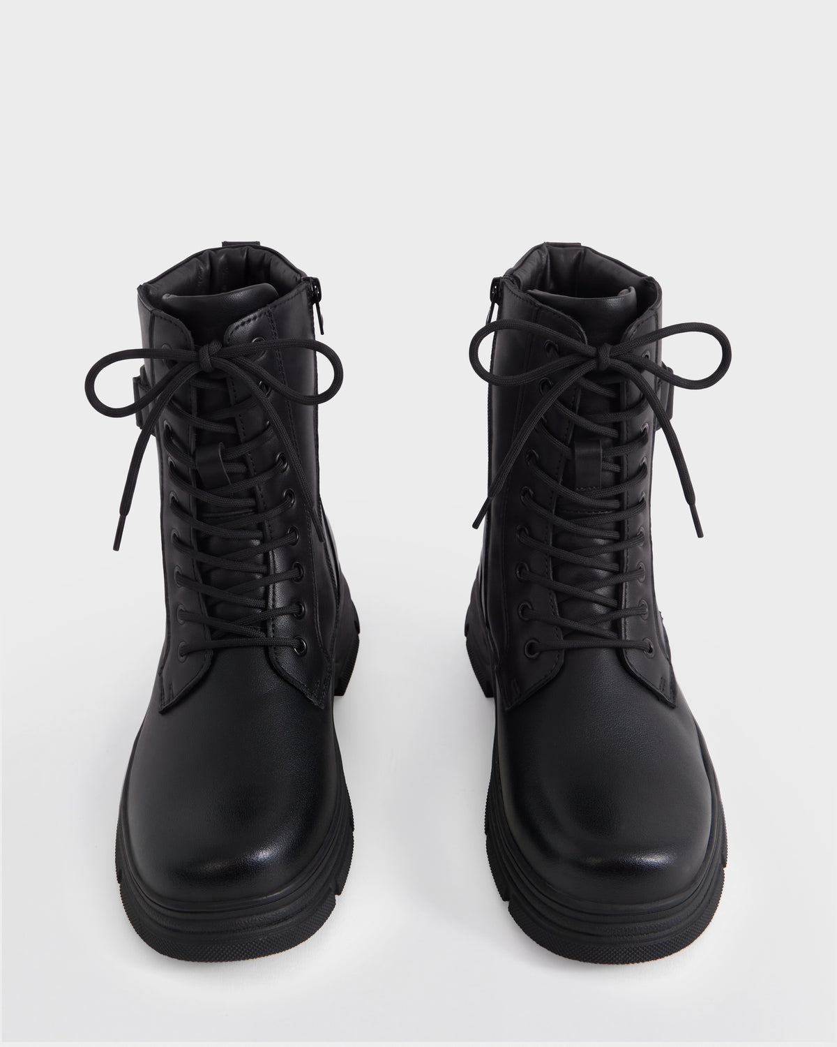The DEREK - 6226506 Black by Rudsak: black lace-up combat boots with round toes, shown from the front on a plain white background.