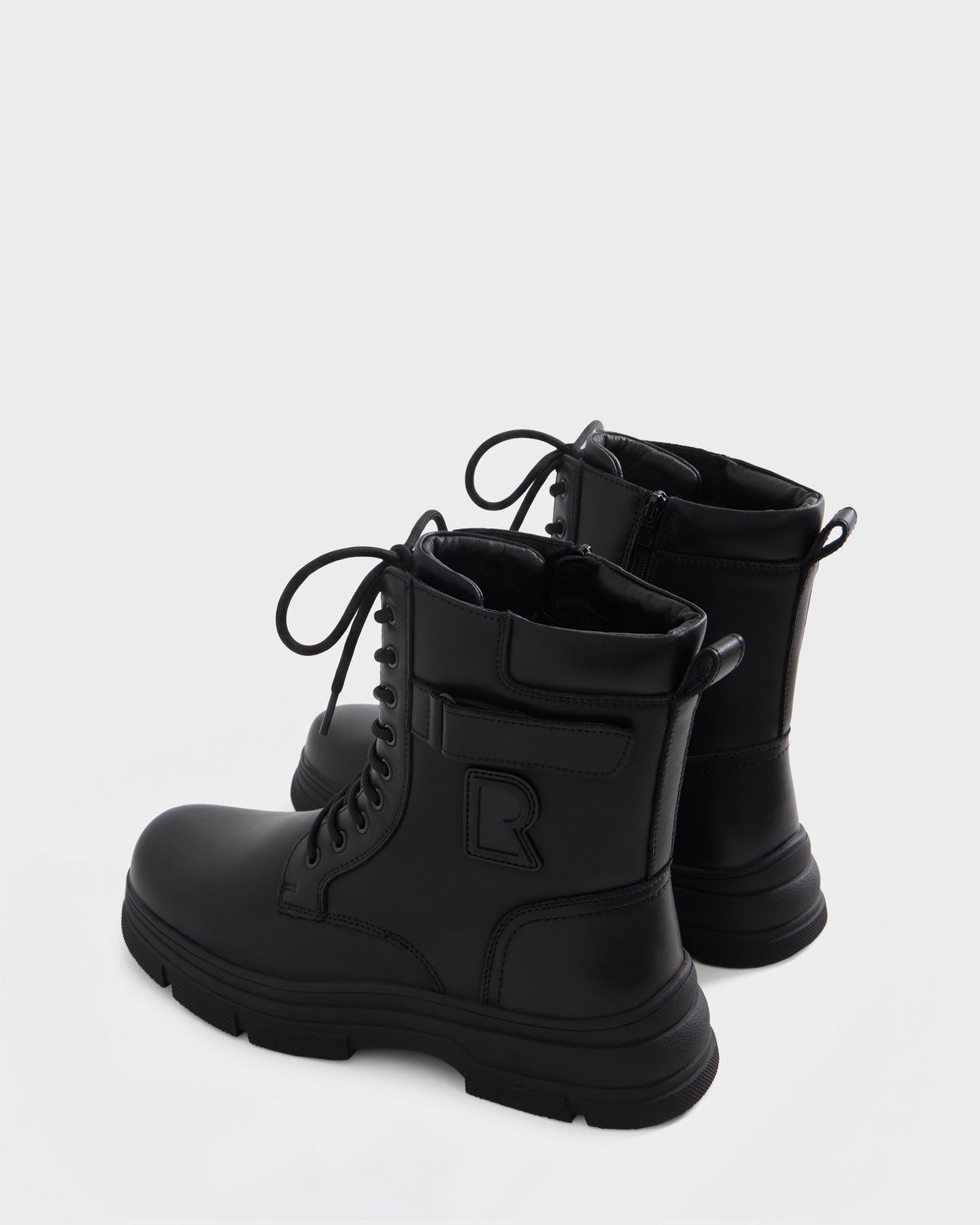 DEREK - 6226506 Black by Rudsak: black lace-up combat boots with thick soles, side zippers, and a stylized R logo on the outer side, shown on a plain white background.