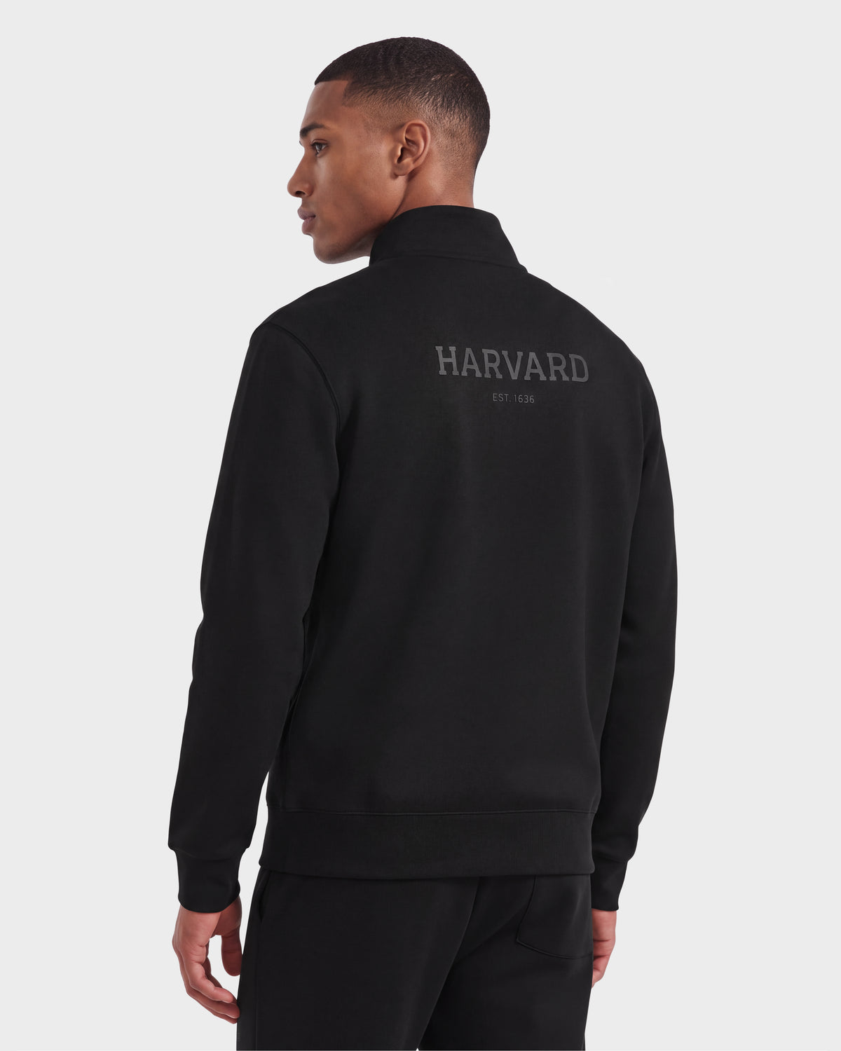 A person wearing a black Rudsak FREMONT HV - H525501 unisex pullover is standing and looking to the side against a plain background.