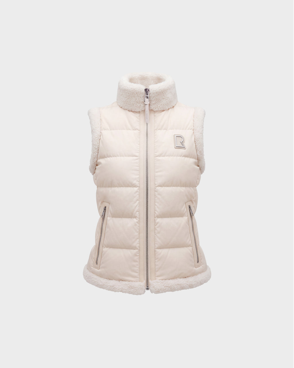 Introducing the HALI - 8126771 Vanilla by Rudsak: a cream-colored, sleeveless puffer vest featuring down insulation and sherpa lining on the collar, armholes, and hem. This vest includes a full zipper, two front zip pockets, and is finished with Rudsak’s signature small embroidered “R” logo on the left chest.