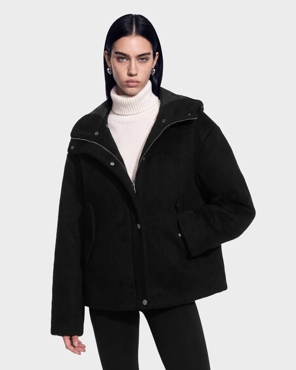 A model wears a black Rudsak HAZEL - 8126981 wool-blend winter coat with a detachable faux-fur hood over a cream-colored turtleneck sweater.