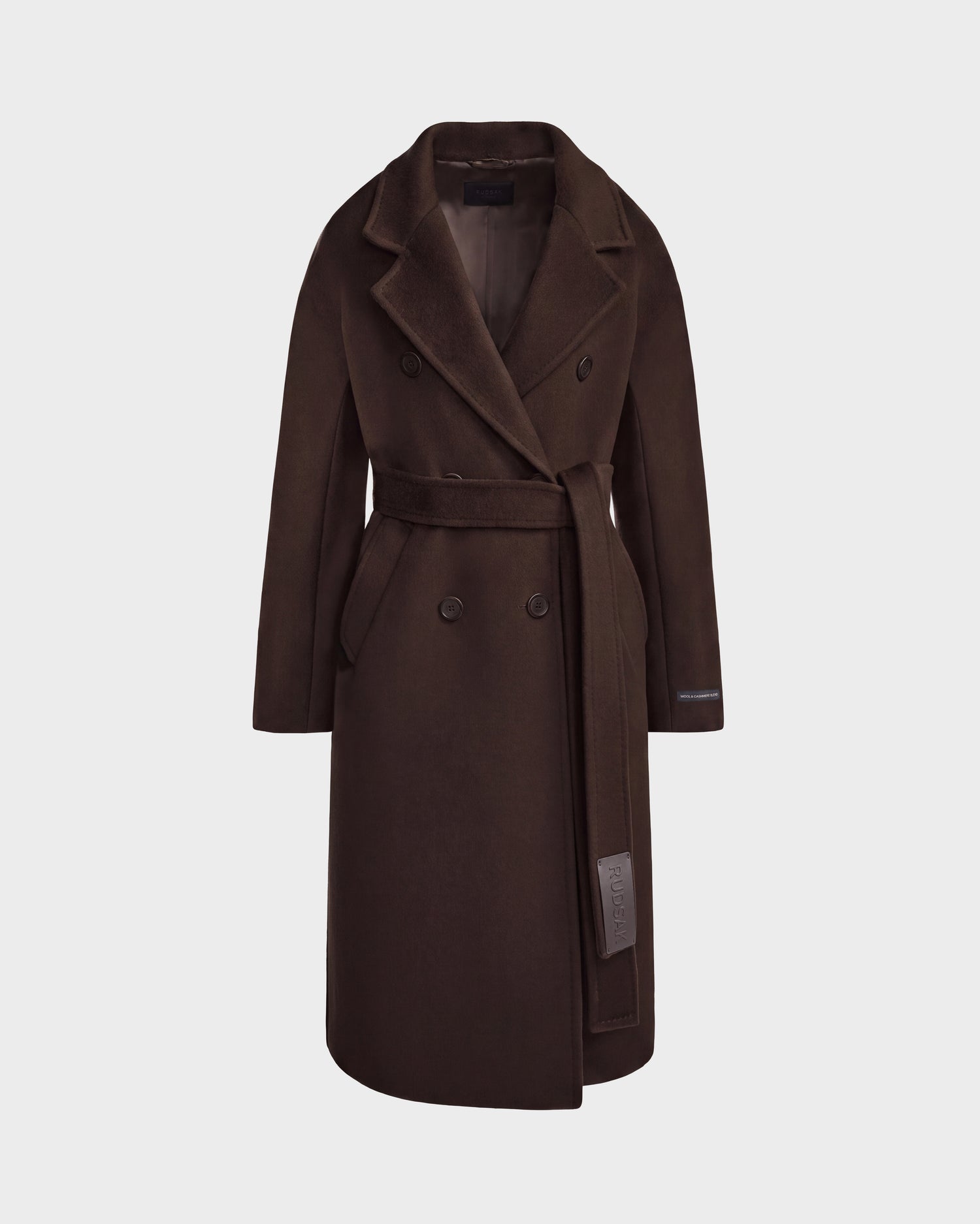 The Rudsak KOURT W - 8124702 Espresso is a long, dark brown coat featuring a double-breasted front, wide lapels, and a matching waist belt, displayed against a plain white background.