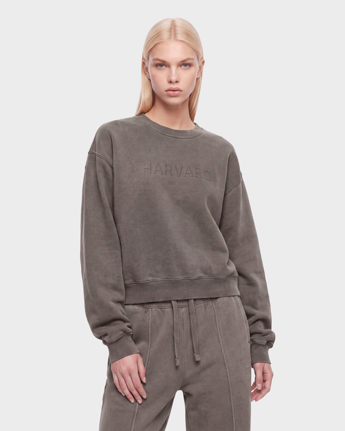 A woman with long blonde hair wears the Rudsak LEXYE HV - H526900 Taupe set, standing against a plain white background.