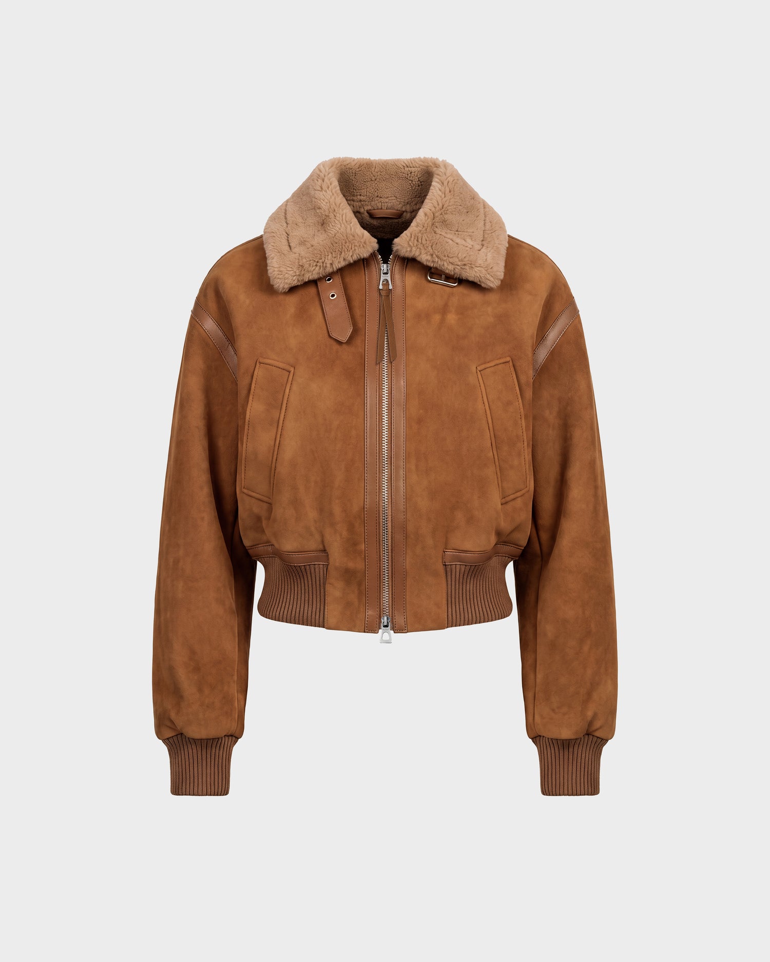 The LIZZIE - 8126787 Tan bomber jacket by Rudsak features brown suede with a wide, soft faux fur collar, ribbed cuffs and waistband, a front zipper closure, two large front pockets, and a buckle detail at the neck. The jacket is displayed against a plain white background.