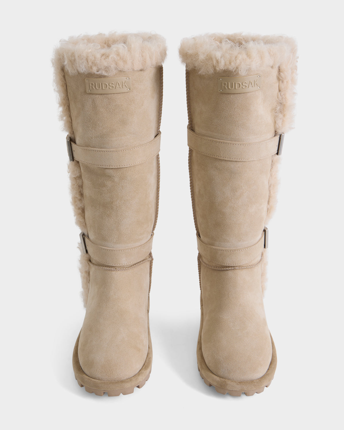 Pair of MISTRA - L226506 Cream knee-high shearling-lined boots with side buckles and lug soles.
