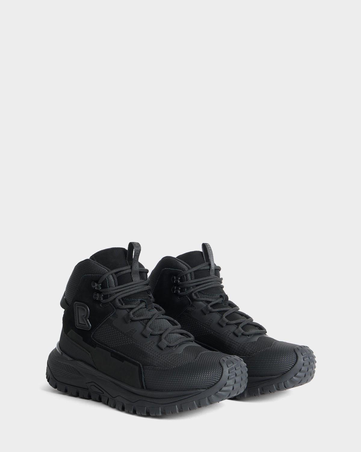 A pair of REXON - 6226503 Black high-top athletic sneakers by Rudsak, featuring textured gray soles, mesh panels, and laces, displayed against a plain light gray background.