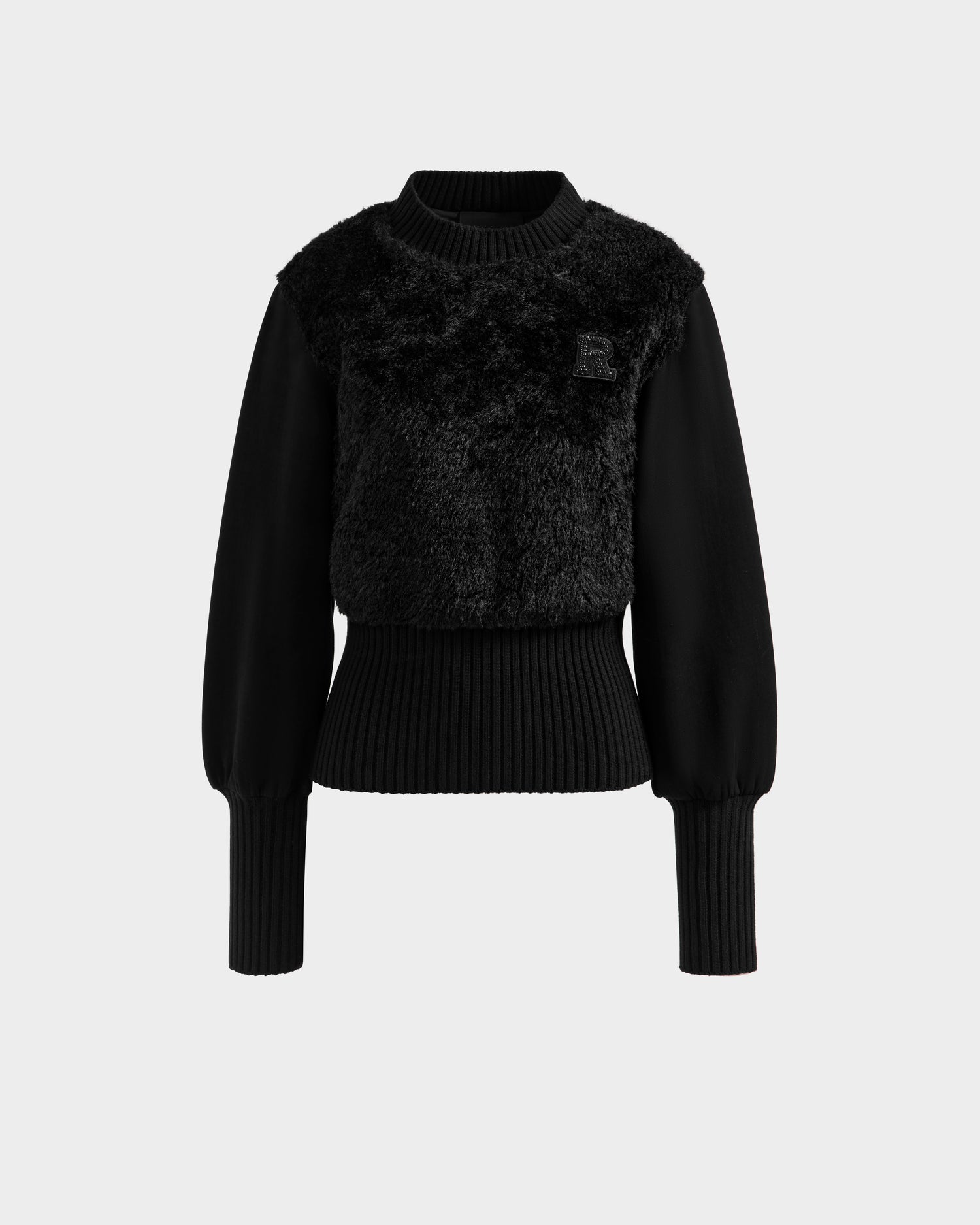 The Rudsak FLORENCE - 8525546 Black sweater features a faux fur textured upper front, ribbed knit cuffs and waist, plus a chest patch detail—adding cozy glamour to any women’s après-ski look. Displayed on a plain white background.