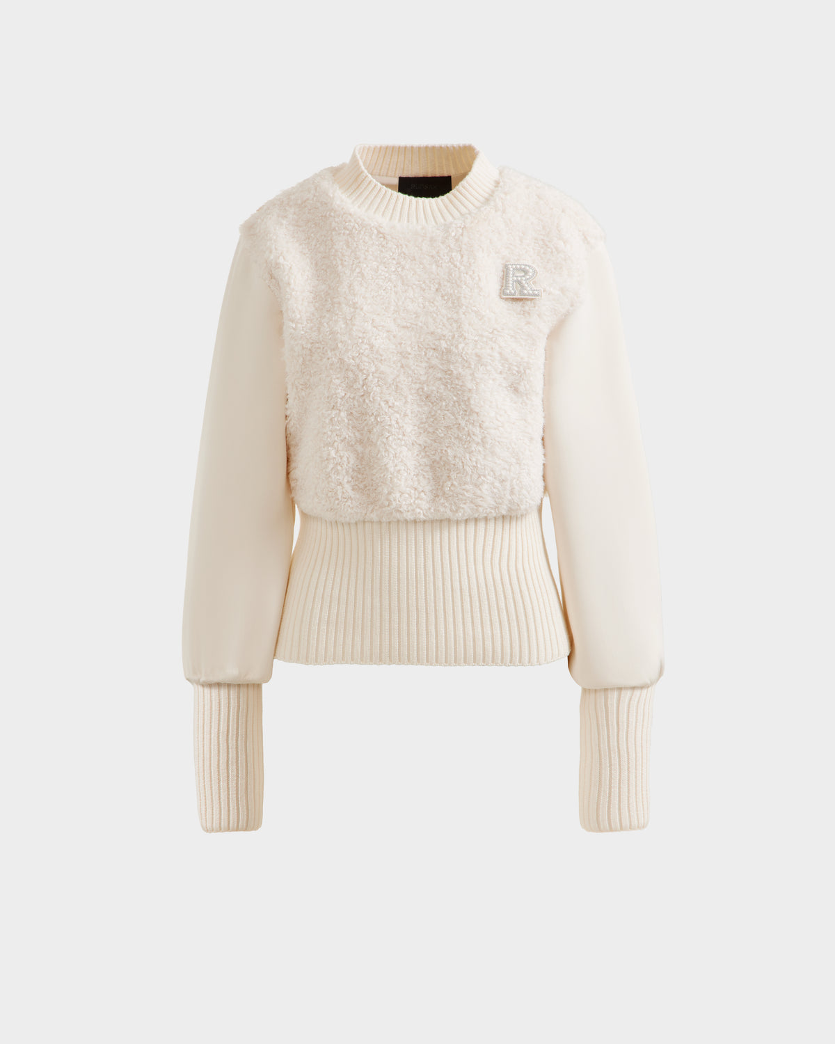 The Rudsak FLORENCE - 8525546 Iceland is a cream après-ski women's top with a textured faux fur front, long ribbed knit sleeves and waistband, and a subtle R patch on the chest—combining cozy glamour with casual style.