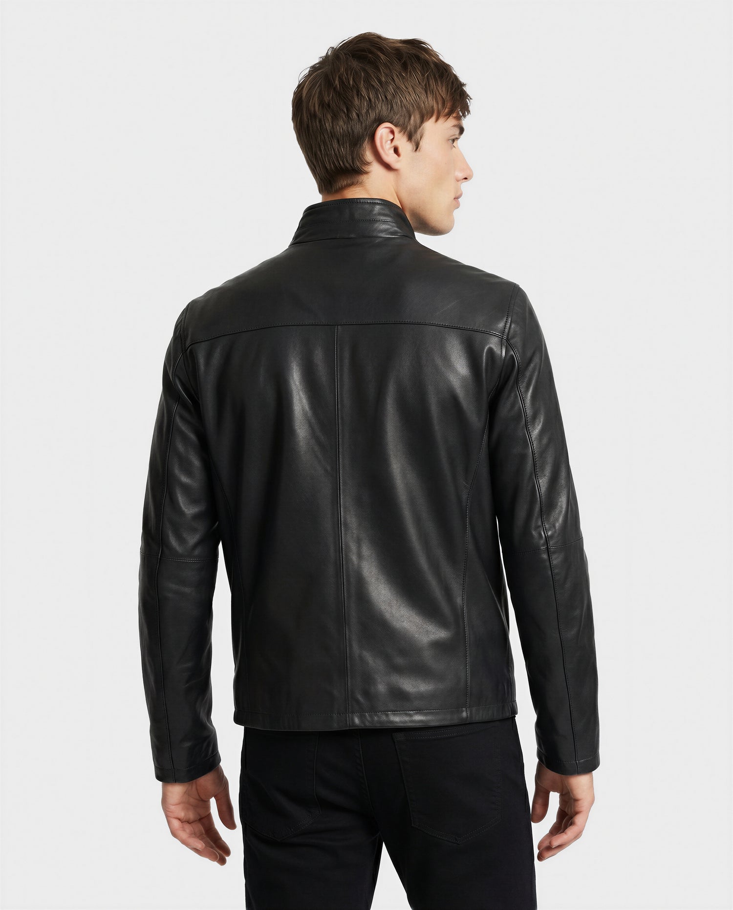 A man with short brown hair stands facing away against a white background, wearing the Rudsak GARY - M126061 Black leather jacket and black pants.