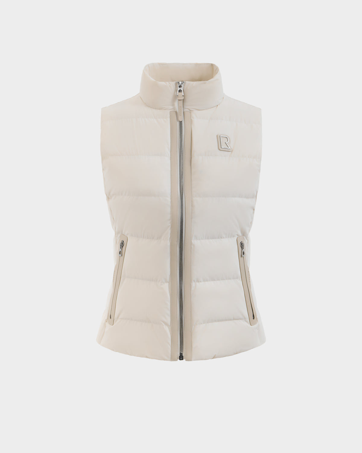 The Rudsak GABRIELA - 8125014 Vanilla is a light beige women’s sleeveless down puffer vest with a high collar, front zipper, vegan leather trim, two zippered pockets, and an embossed logo on the left chest, shown on a white background.