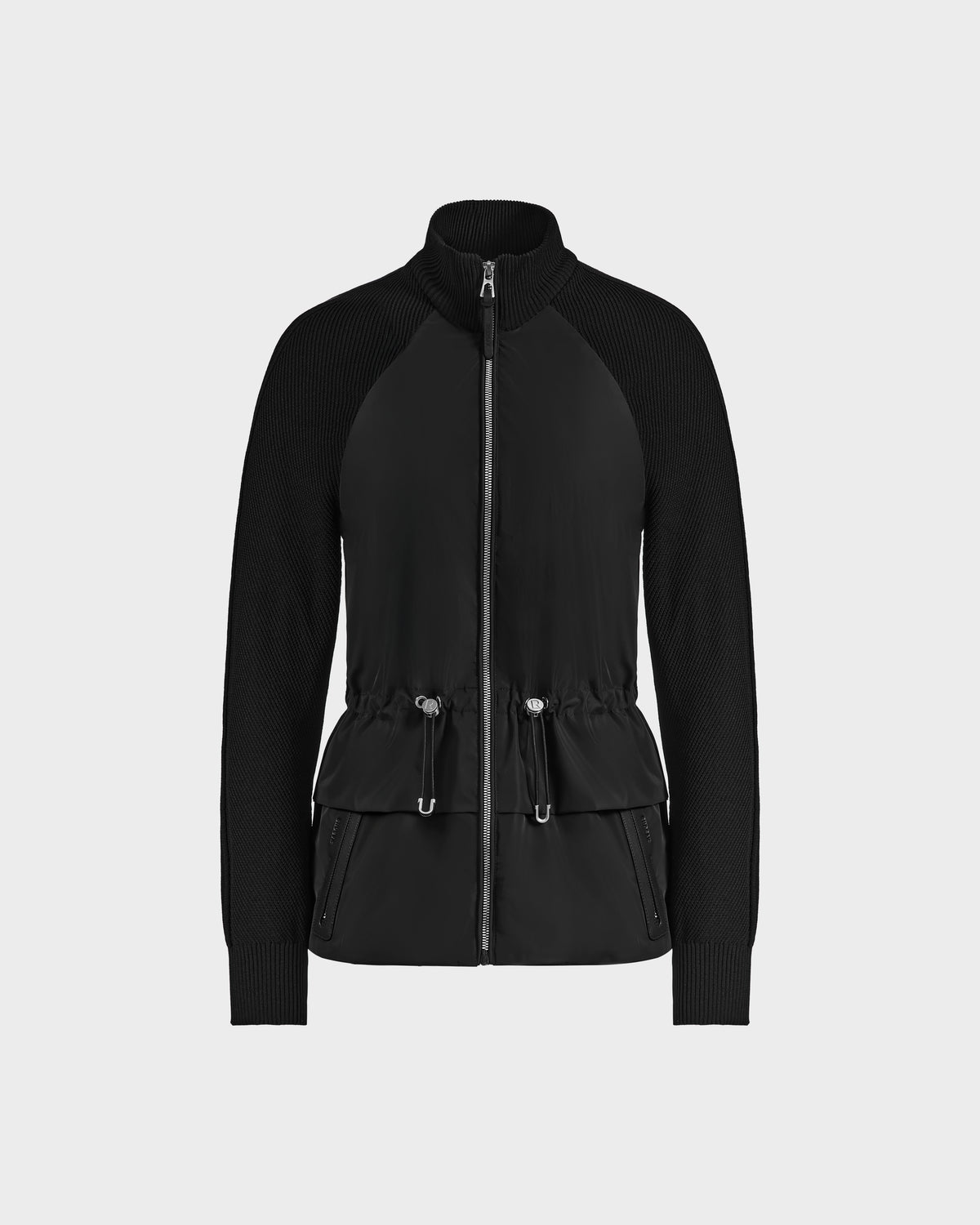 The Rudsak GENEVIEVE - 8125042 Black hybrid jacket features ribbed sleeves, a drawstring waist, zippered front pockets, and a wind-resistant shell—ideal for transitional weather. Shown on a plain light gray background.