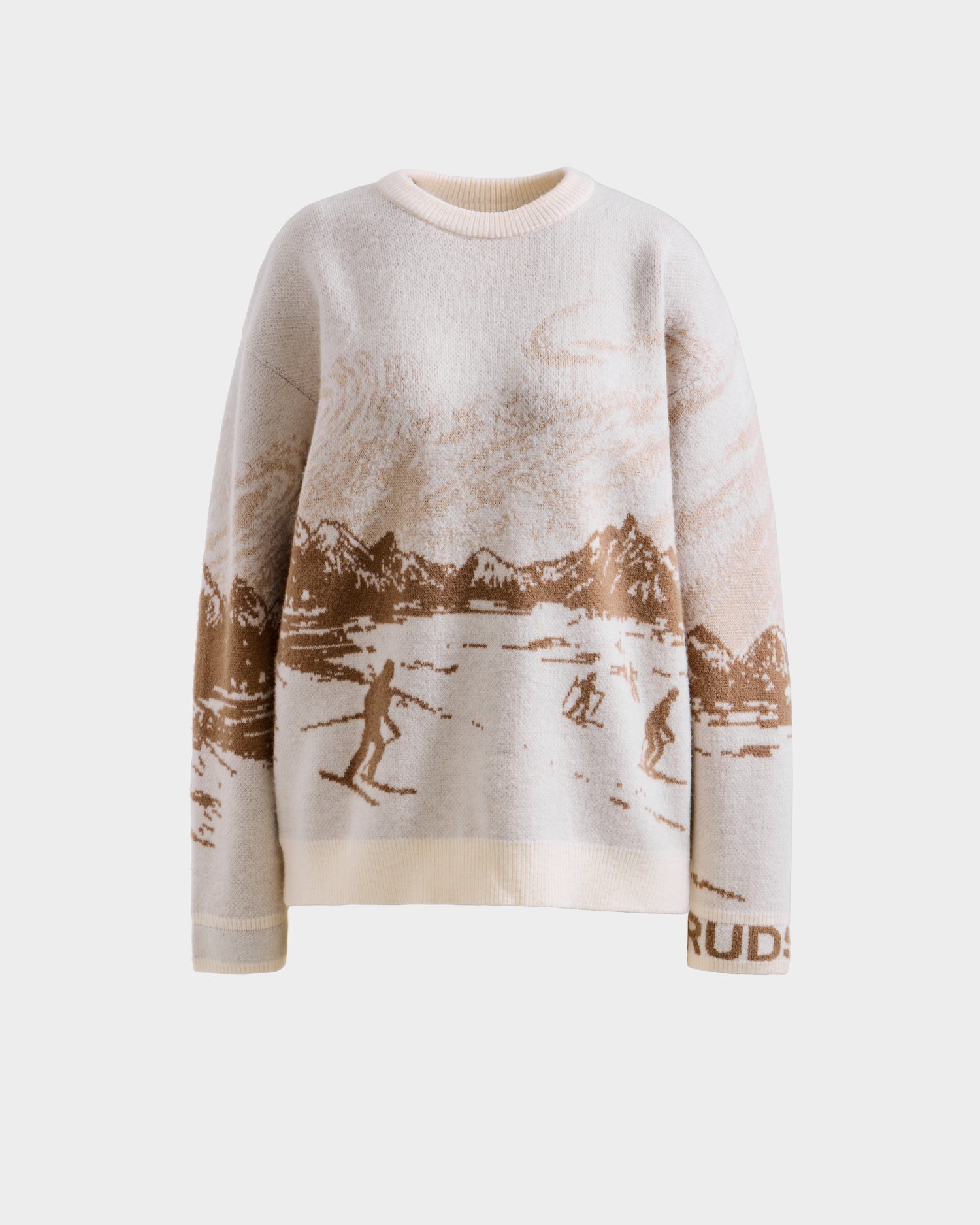 The Rudsak IZZY - 9525557 Iceland M is a cream and beige unisex sweater with a ski mountain motif, skiers, trees, and snowy peaks. Ideal for après-ski style, it features "RUDS" partially on the left sleeve cuff.
