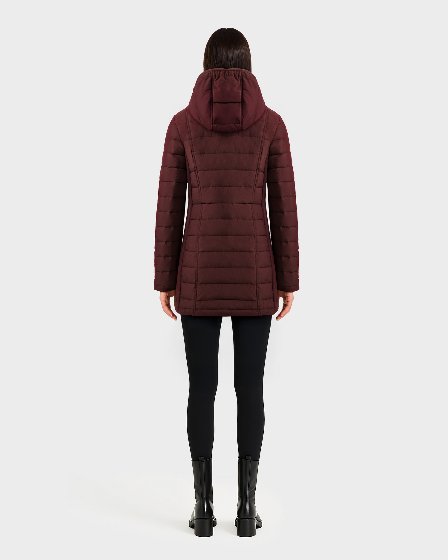 A person wears the Rudsak CORDELIA - 4124519 Burgundy down puffer coat, paired with black leggings and boots, standing facing away against a plain white background.