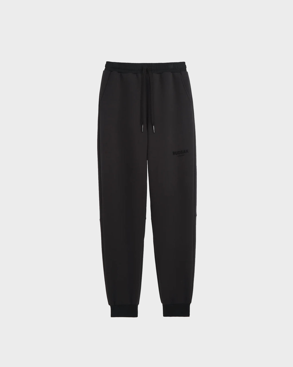 The Rudsak JOSS - 9524009 Black M sweatpants, made from a premium cotton blend with an elastic waistband, drawstring, elastic cuffs, and side pockets, are shown against a plain light gray background.