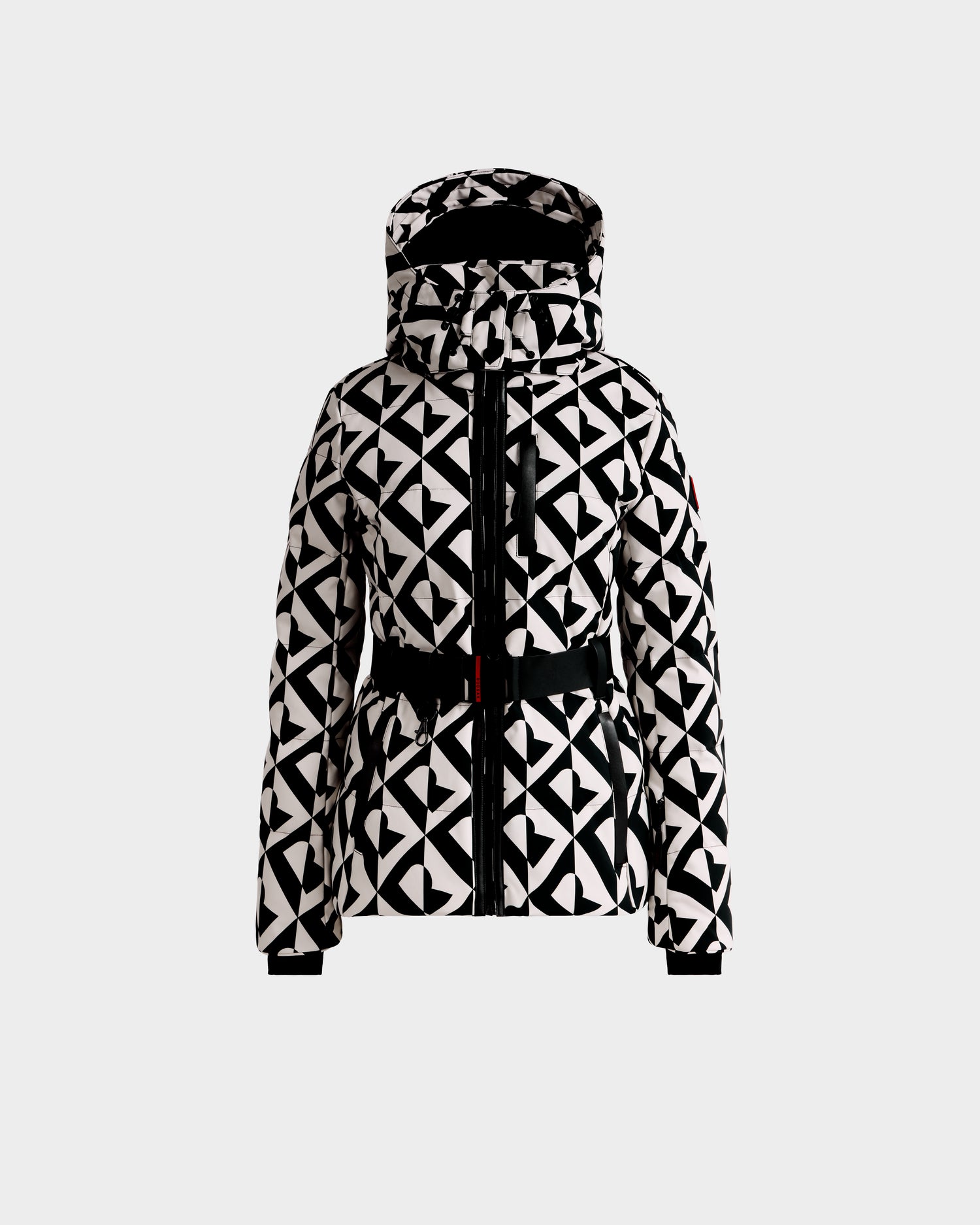 The JOANNA P - 8125623 Vanilla Monogram by Rudsak is a black and white geometric hooded jacket with a front zipper, black waist belt, and long sleeves. Displayed on a light background. Pre-order now; ships by Nov 30.