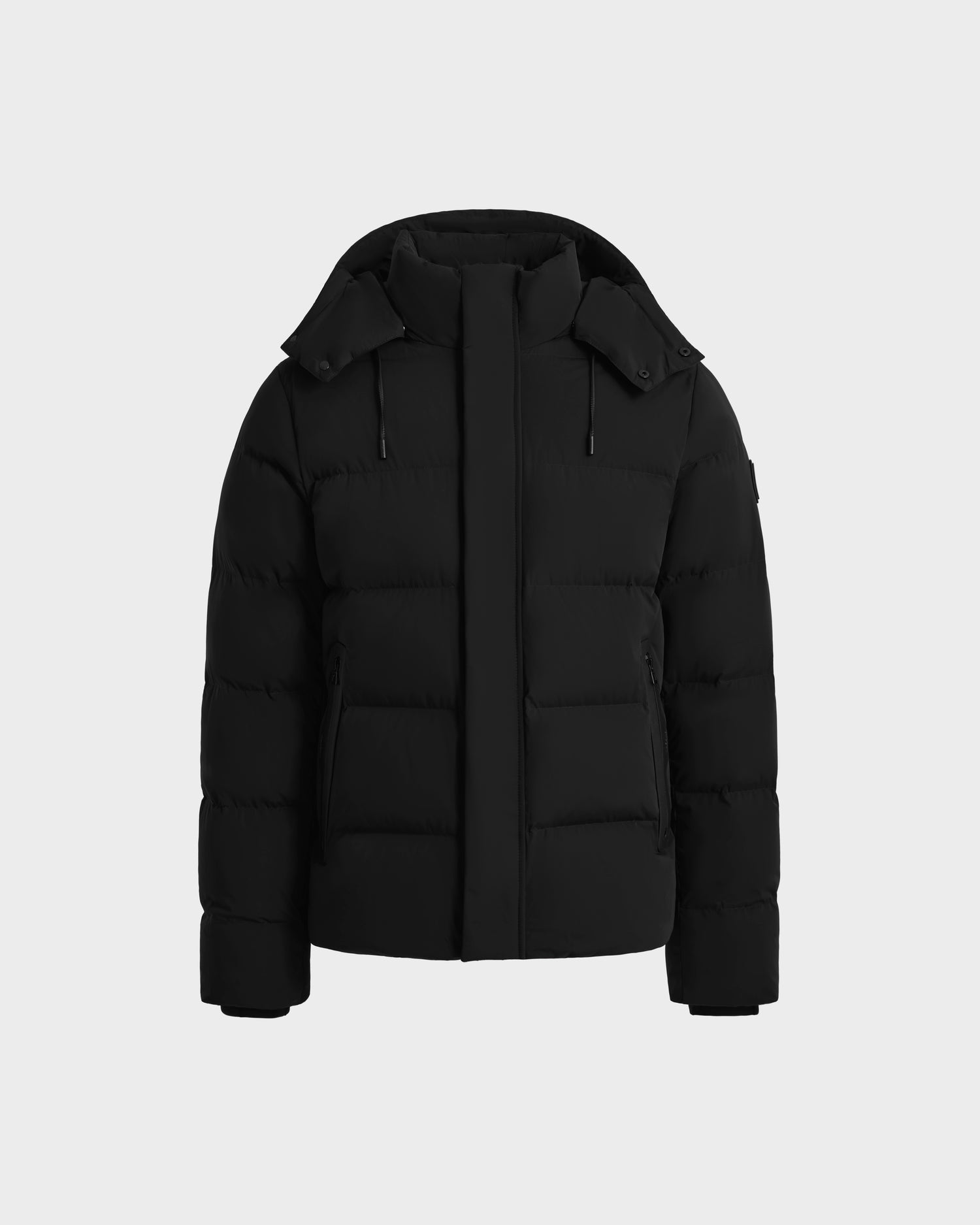 The Rudsak JOEL - 6124605 Black men’s puffer jacket, shown on a light gray background, features a high collar, detachable hood, front zipper closure, and two zippered side pockets—ideal for cold-weather wear.