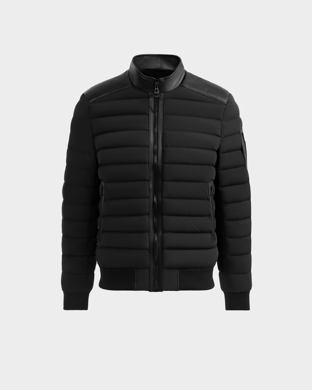 The Rudsak JOSHUA - 6125722 Black is a black quilted light jacket featuring a front zipper, ribbed cuffs and hem, and a stand-up collar, shown against a plain light gray background.
