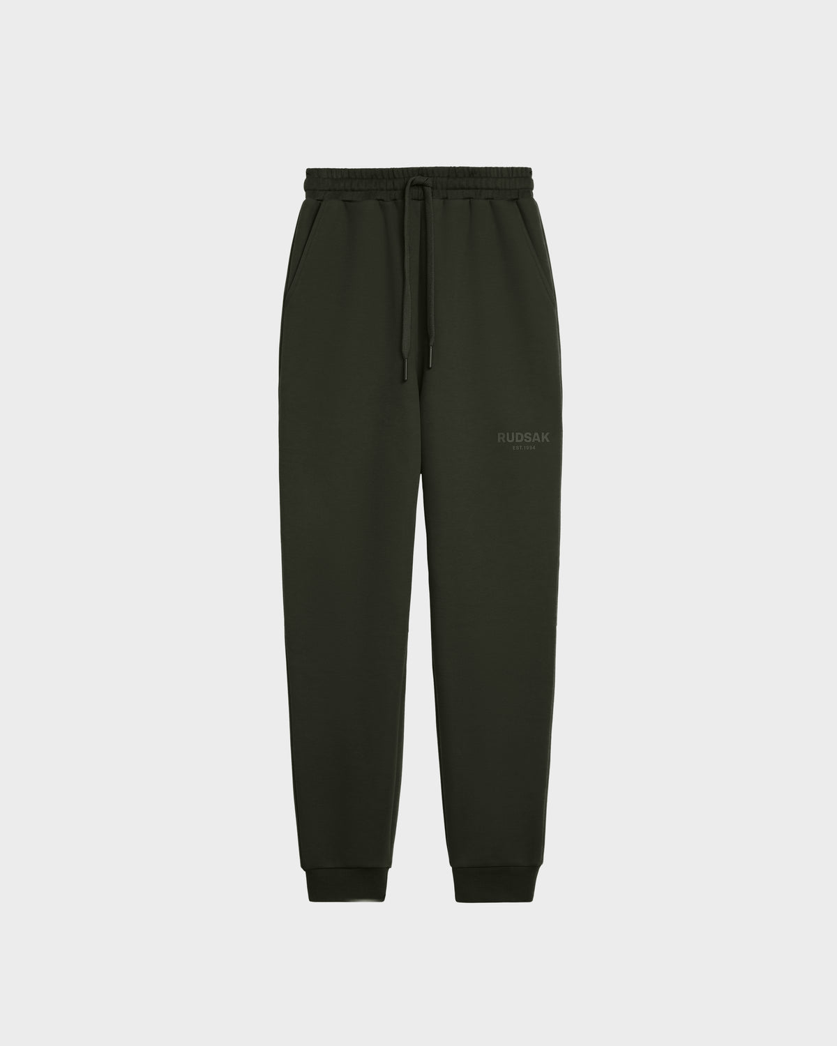 JOSS - 9524009 Dark Olive W unisex jogger sweatpants by Rudsak, featuring an elastic waistband, drawstring, side pockets, ribbed ankle cuffs, and a subtle Rudsak logo on one thigh, shown on a plain white background.