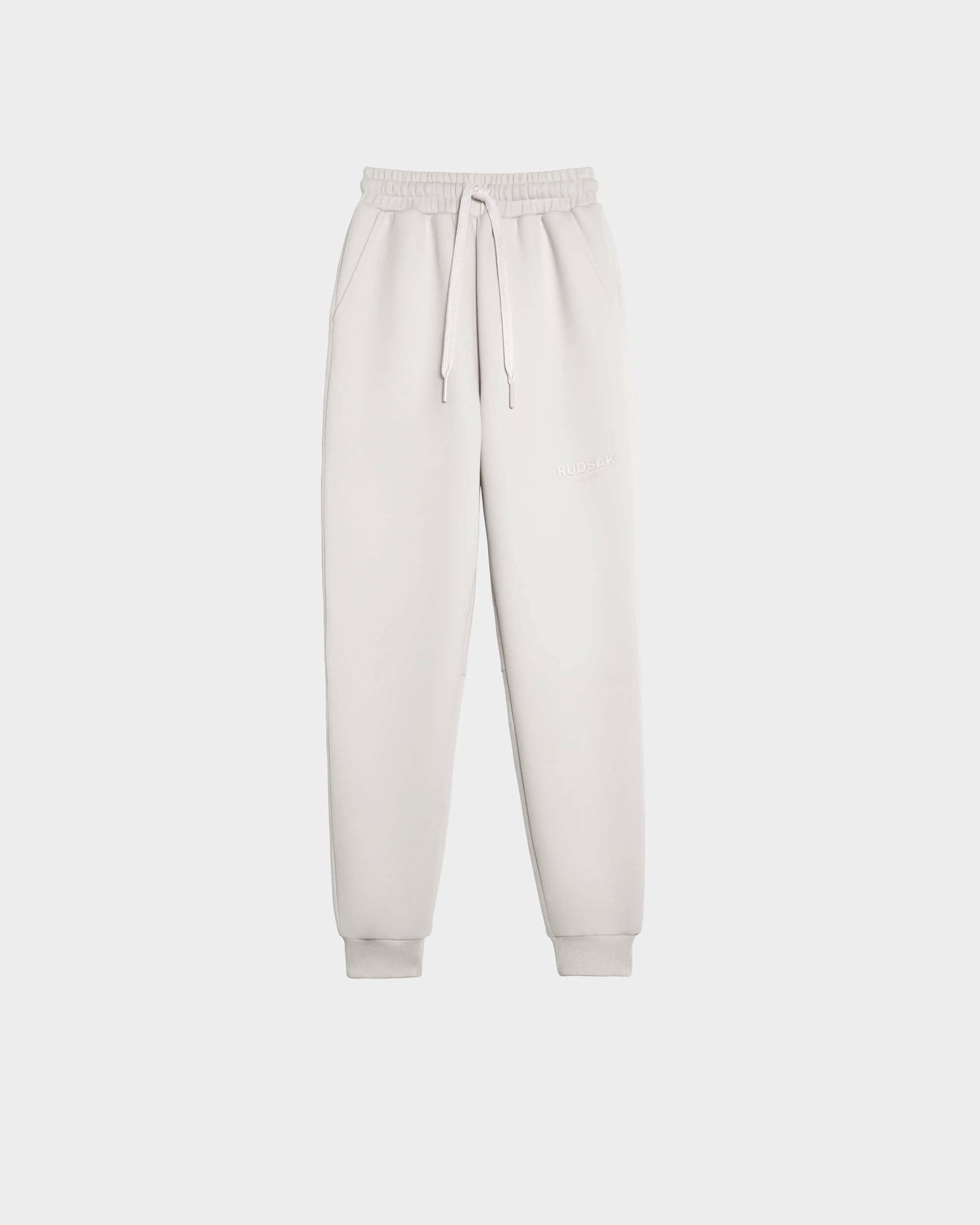 The Rudsak JOSS - 9524009 Vanilla M jogger sweatpants feature a light grey unisex design in premium cotton blend with elastic waistband, drawstring tie, side pockets, and cuffed ankles, shown against a plain white background.