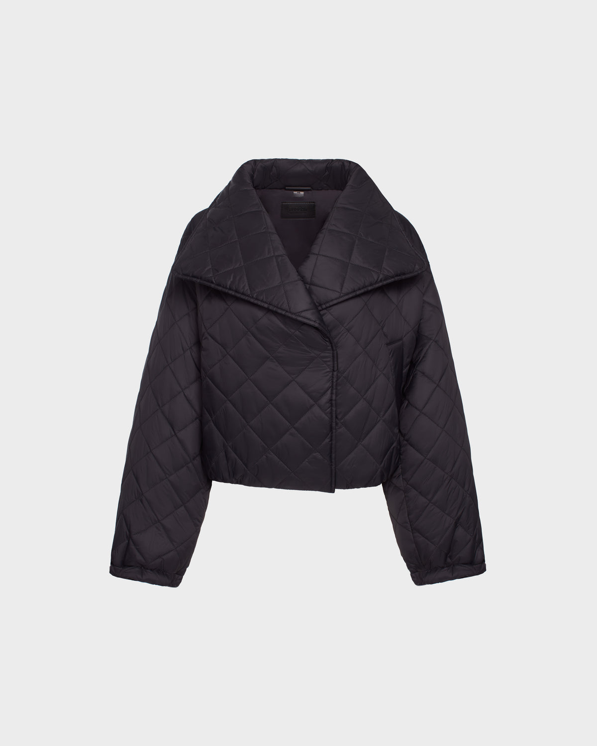 The Rudsak KALEE - 8124005 Black quilted light jacket features a wide collar and asymmetrical front closure, shown against a plain light background.