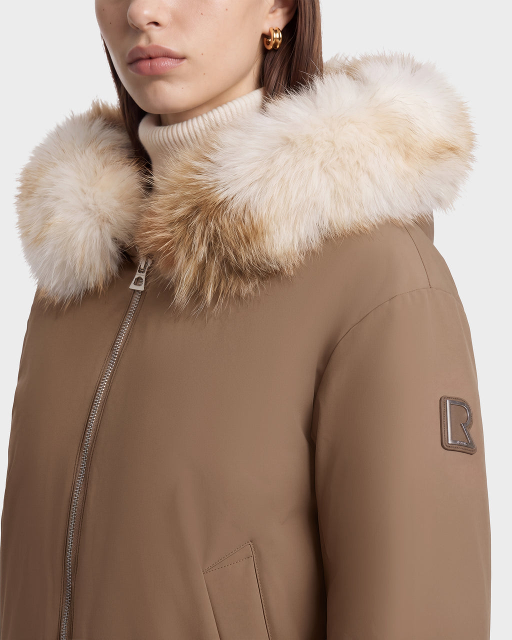 Sand-colored Rudsak KATHLEEN - 8126764 winter bomber jacket with a faux-fur trimmed hood and a logo patch on the left sleeve.