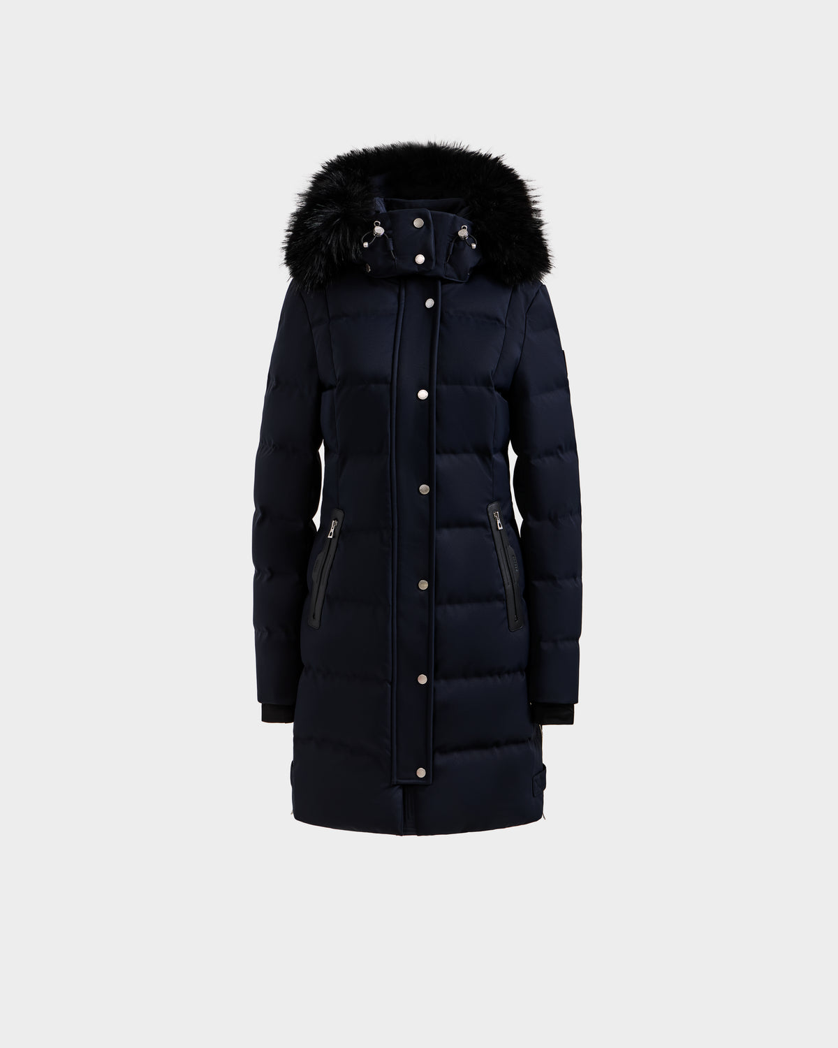 The Rudsak KEHLANI H - 8125643 Navy is a women’s long, dark navy down-filled parka featuring a front zipper with snap buttons, two zippered side pockets, and a black faux fur-trimmed hood, shown against a plain light grey background.