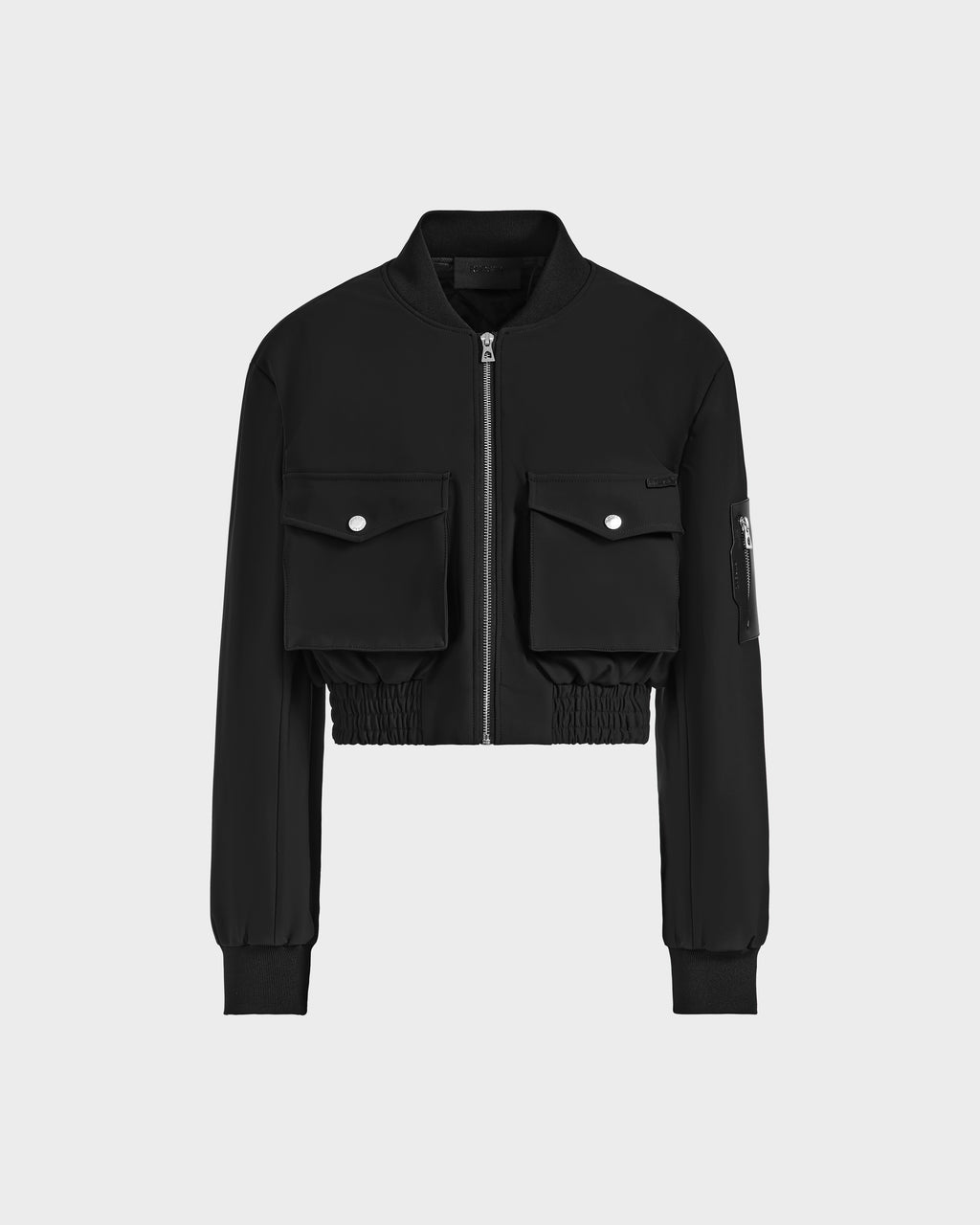 The KEIRA - 8525024 Black by Rudsak is a black cropped bomber jacket with lightweight fabric, front zipper, two flap chest pockets with snap buttons, ribbed cuffs and waistband, plus a zip pocket on the left sleeve.