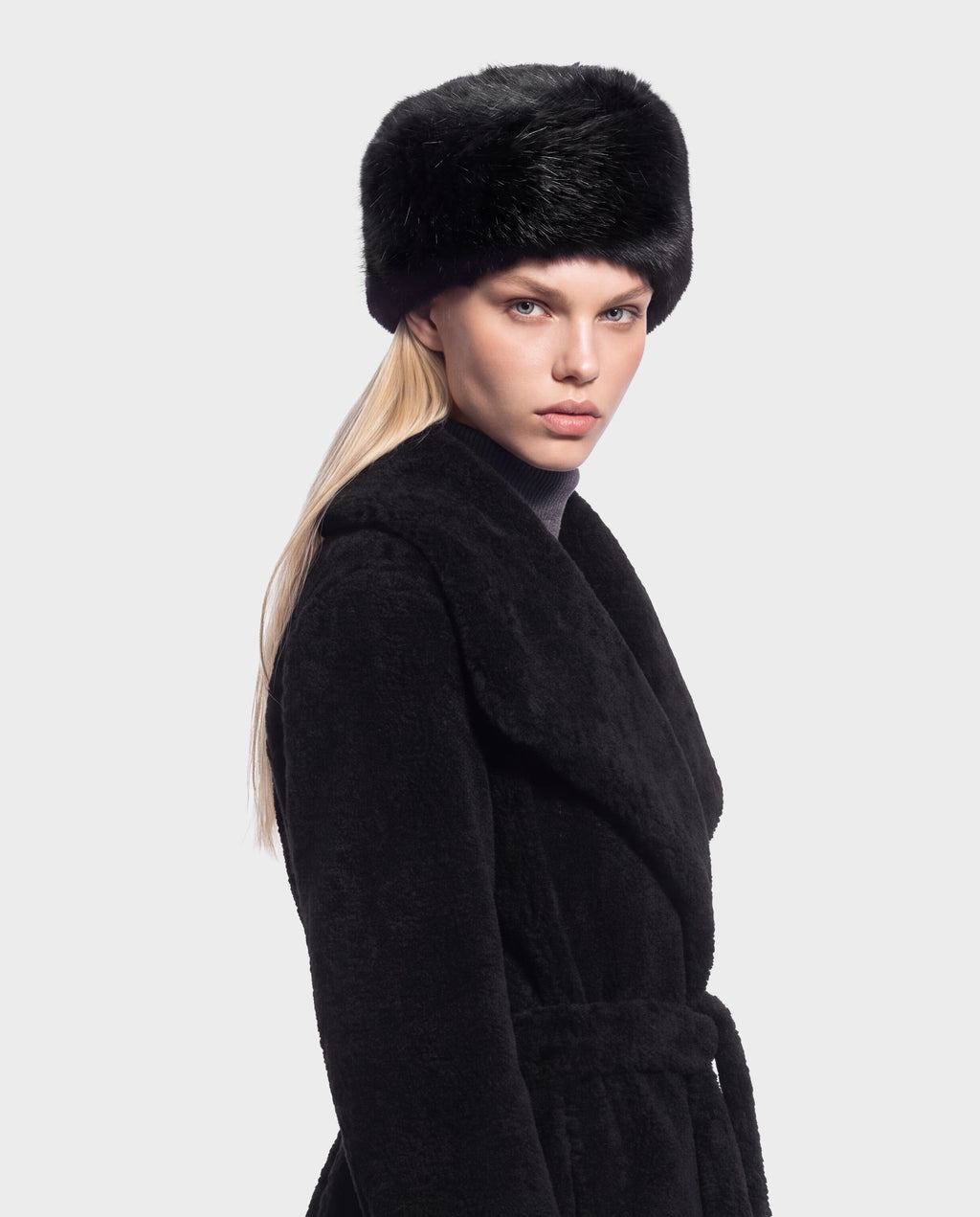 A person wearing the LORETTA - 8426503 Black coat, a black belted coat, and a black fur-style pillbox hat.