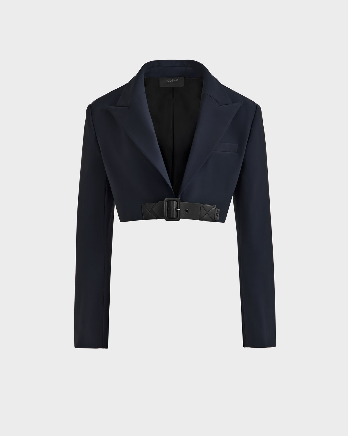 The Rudsak LEXI - 8525026 Black is a chic women’s cropped blazer with long sleeves, wide lapels, and a belted waist, styled against a light gray background—perfect for modern wardrobes.