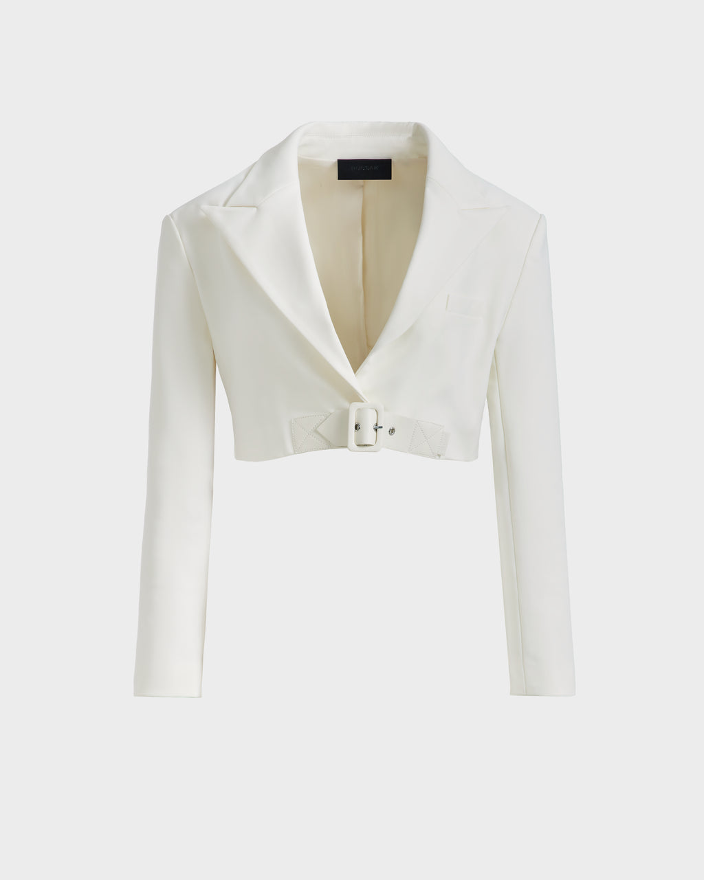 The LEXI - 8525026 Iceland by Rudsak is a women’s white cropped blazer with long sleeves, wide notched lapel, a front pocket, and a matching vegan leather belt—ideal for power dressing with modern flair.