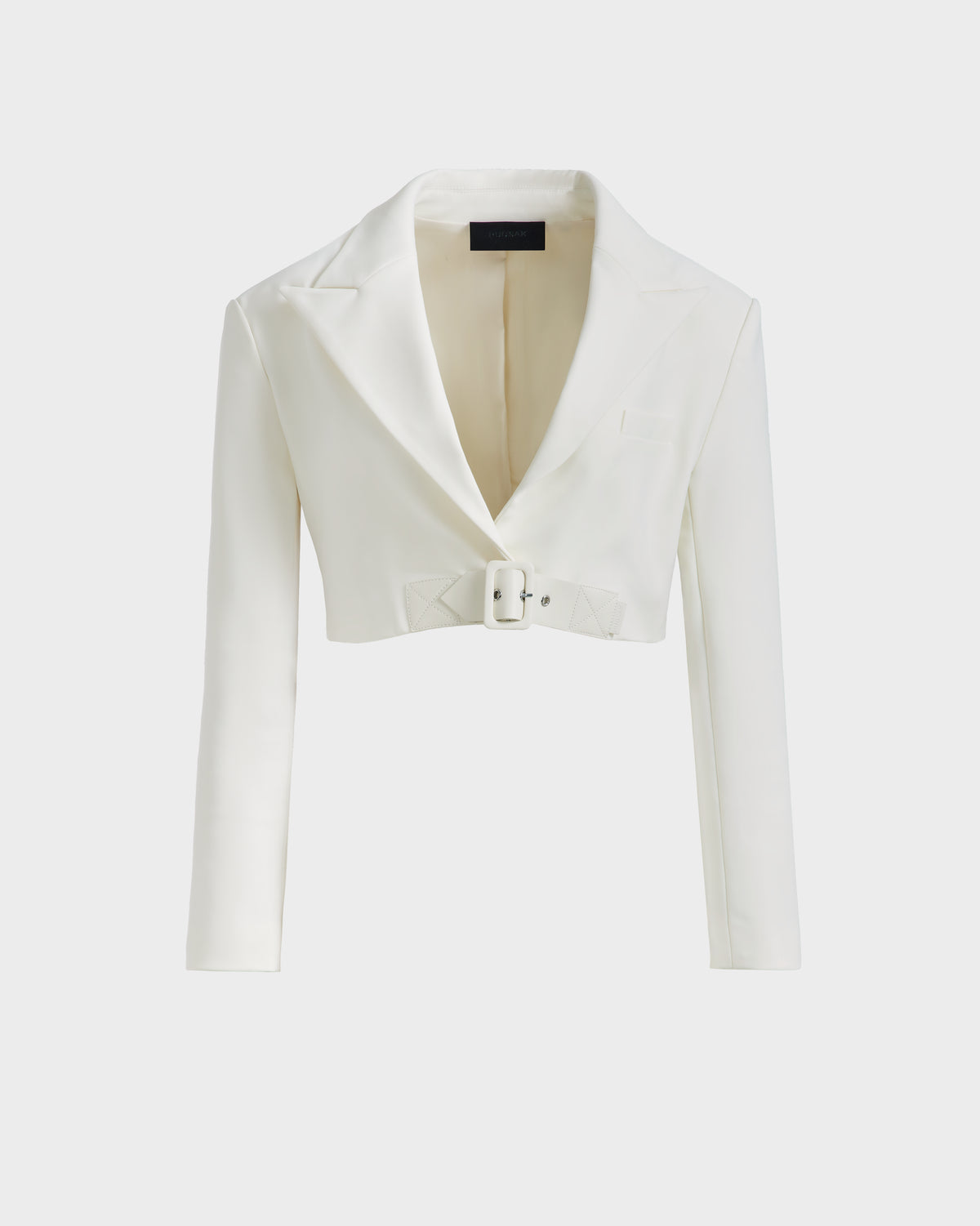 The LEXI - 8525026 Iceland by Rudsak is a women’s white cropped blazer with long sleeves, wide notched lapel, a front pocket, and a matching vegan leather belt—ideal for power dressing with modern flair.