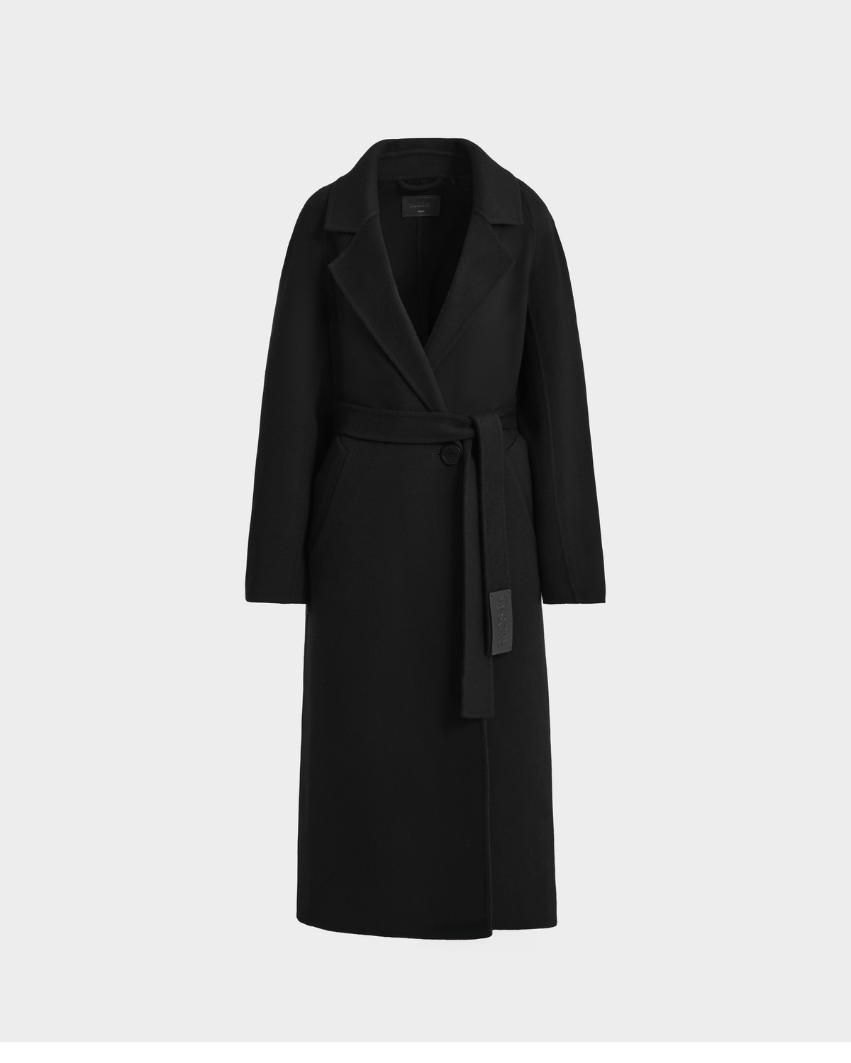 The LILIA - 8125634 Black by Rudsak is a women’s long wrap coat with wide lapels and a matching belted waist, crafted from a wool-silk-cashmere blend. Shown on a plain light gray background, it’s the perfect transitional layering piece.