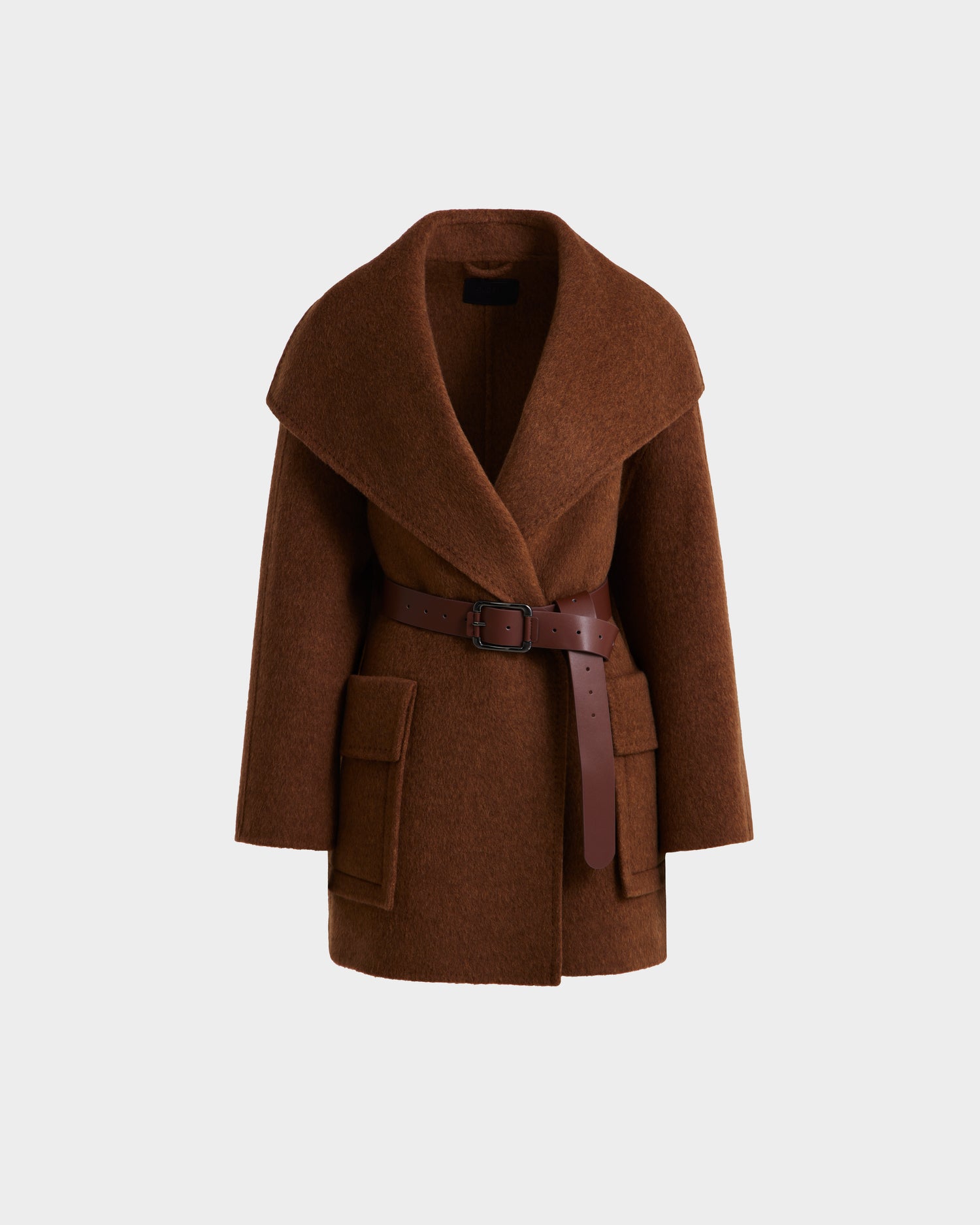The Rudsak LUCIA - 8125633 Camel is a women’s brown wool jacket with wide lapels, large front pockets, and a dark brown vegan leather belt at the waist, shown against a plain light background.