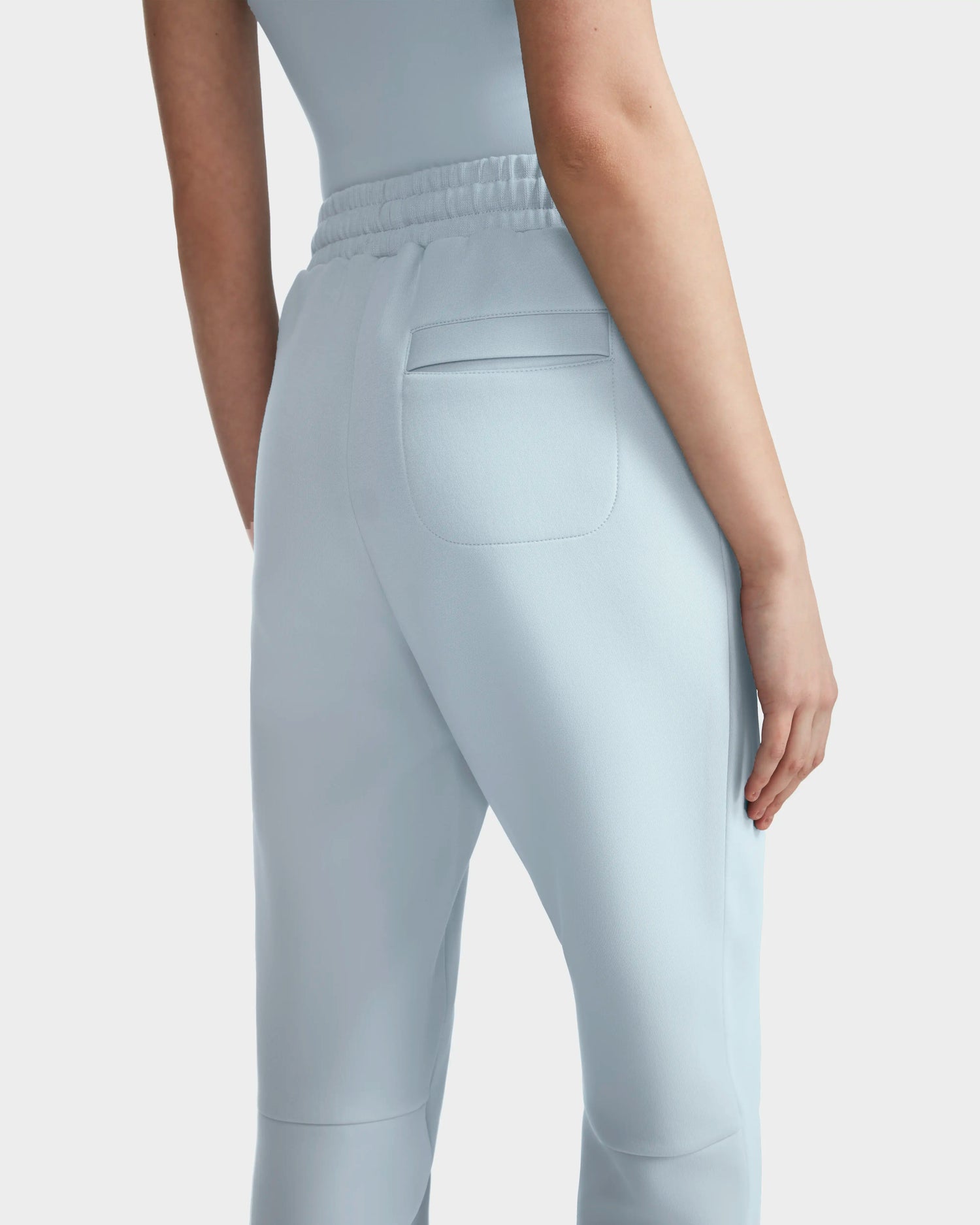 A person is shown from behind, waist down, wearing JOSS - 9524009 Sky Blue W high-waisted premium cotton joggers with an elastic waistband and a back pocket.
