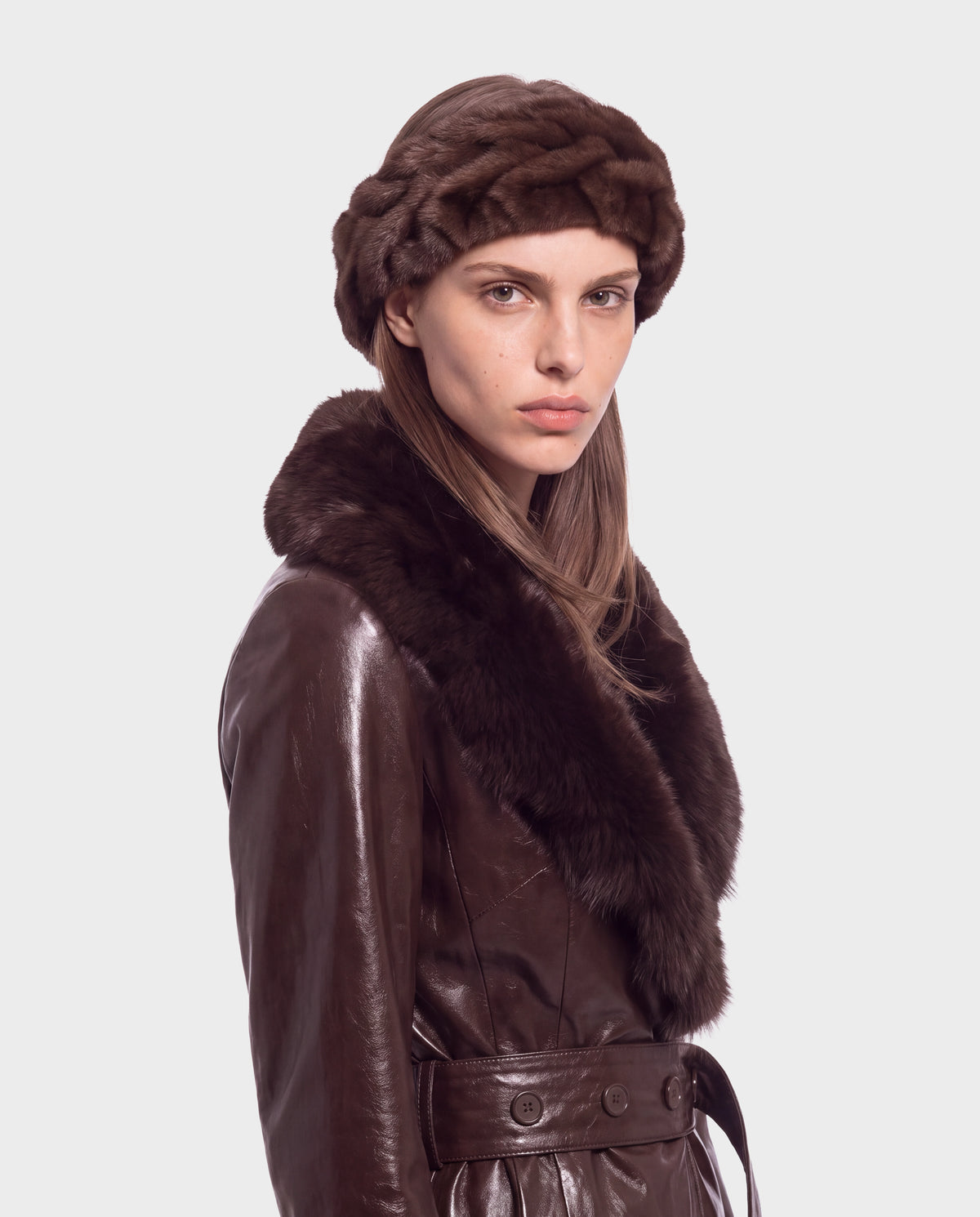 A person wearing a Rudsak MILA - 8426518 Espresso dark brown leather coat with a faux fur collar and a matching faux fur headband.