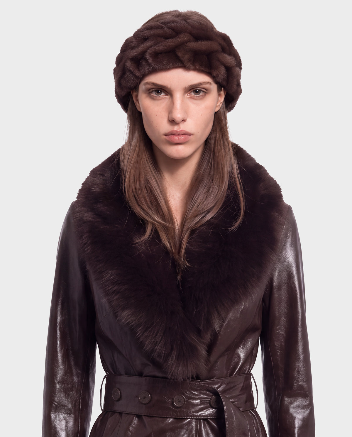 A woman wearing a Rudsak MILA - 8426518 Espresso leather coat with a large fur collar and a matching dark brown fur headband.