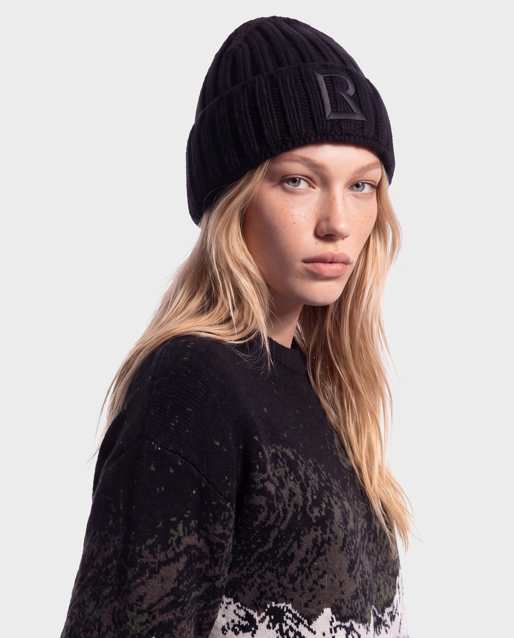 A person wearing a black Rudsak MISSA - 8426512 Black ribbed knit beanie featuring a square logo patch on the front.