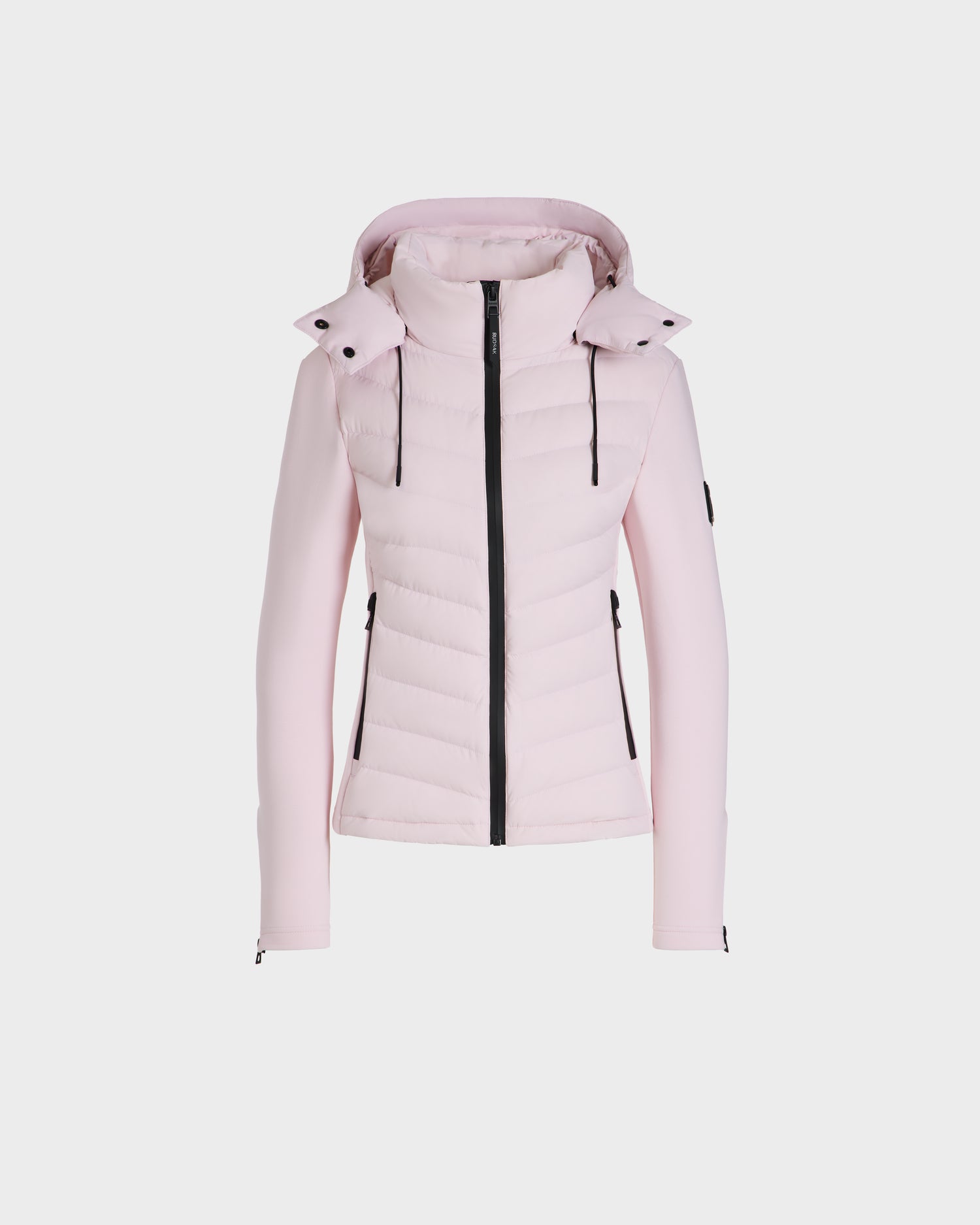 The Rudsak MALYA M - L125036 Light Pink is a down quilted jacket with a hood, black front zipper, drawstrings, zippered pockets, and a left sleeve patch—shown on a plain white background.