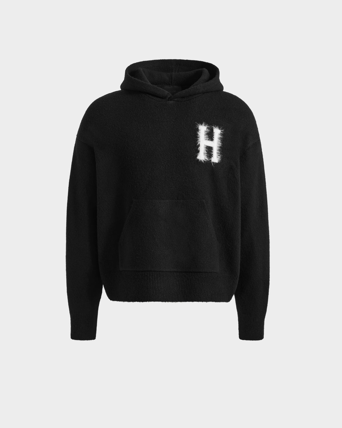 The Rudsak MARCUS HV - H525503 Black hoodie features a large front pocket and a fuzzy white "H" on the left chest, shown on a light gray background—ideal for collegiate style or Harvard hoodie fans.
