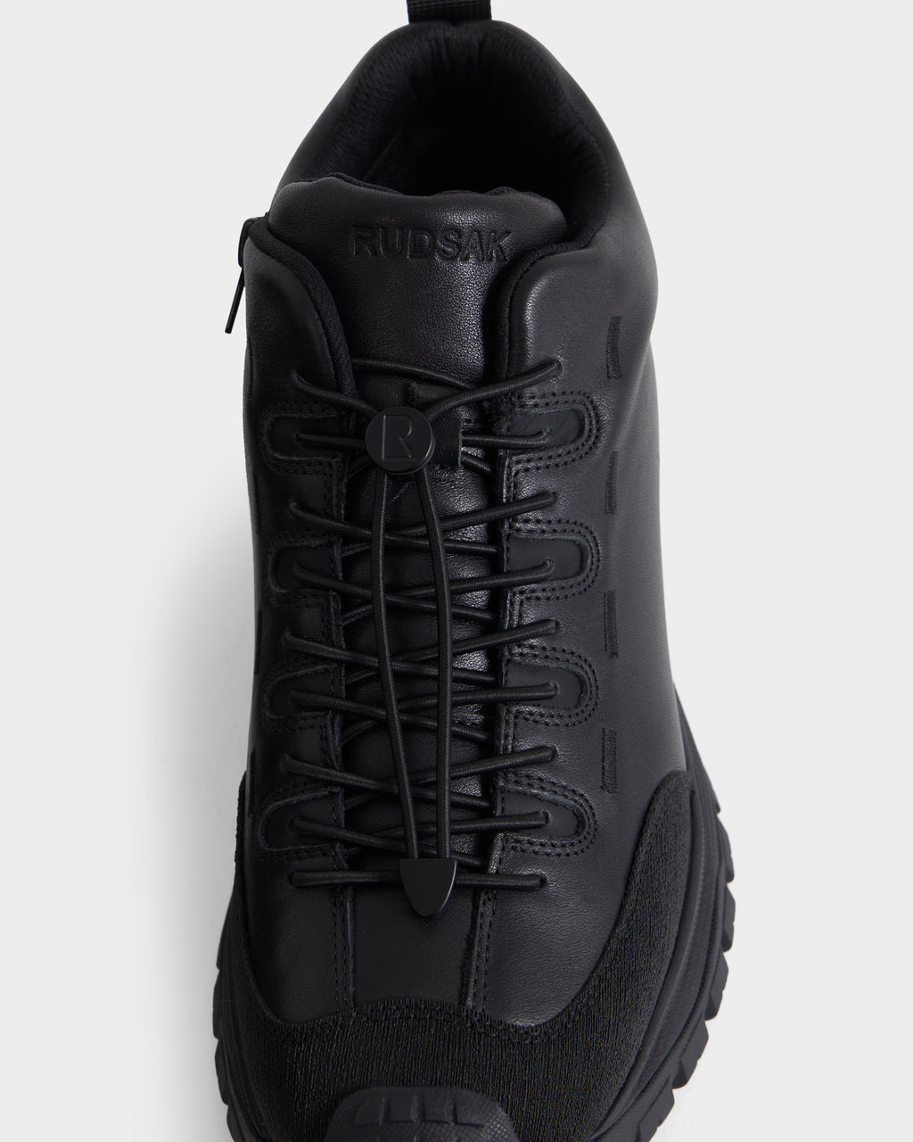 MAX - 6226502 Black men’s sneakers by Rudsak, featuring a utility-inspired design with a thick sole, leather upper, and elastic toggle laces, shown from above against a plain white background.