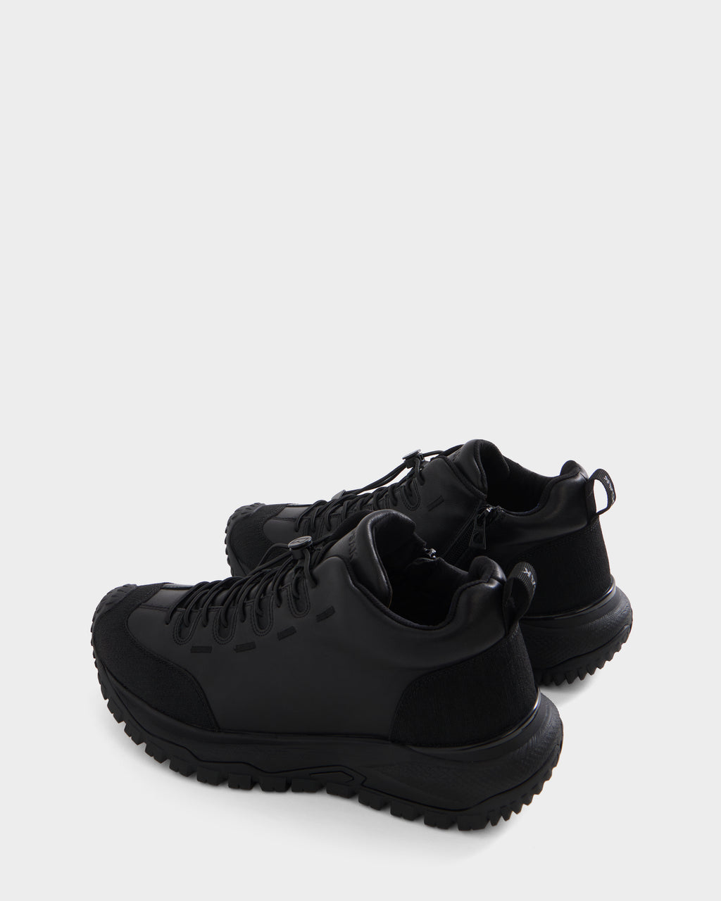 A pair of Rudsak MAX - 6226502 Black utility-inspired athletic sneakers with rugged soles, distinctive side detailing, and black laces, displayed against a plain white background.