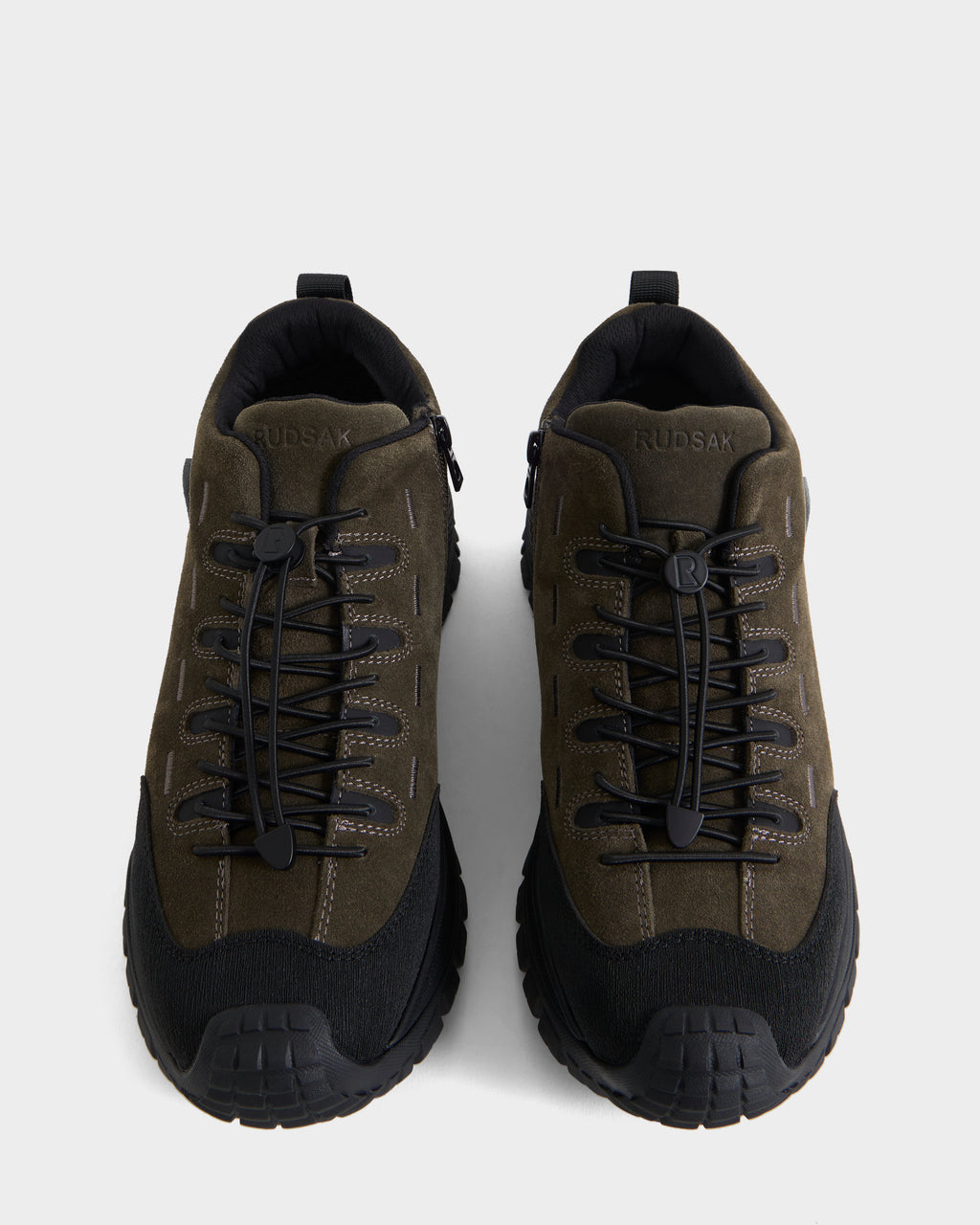 A pair of Rudsak MAX S - 6226505 Olive men’s sneakers in olive green and black, featuring thick rugged soles, dark laces, trail-inspired detailing, and suede accents, shown from above on a plain light background.
