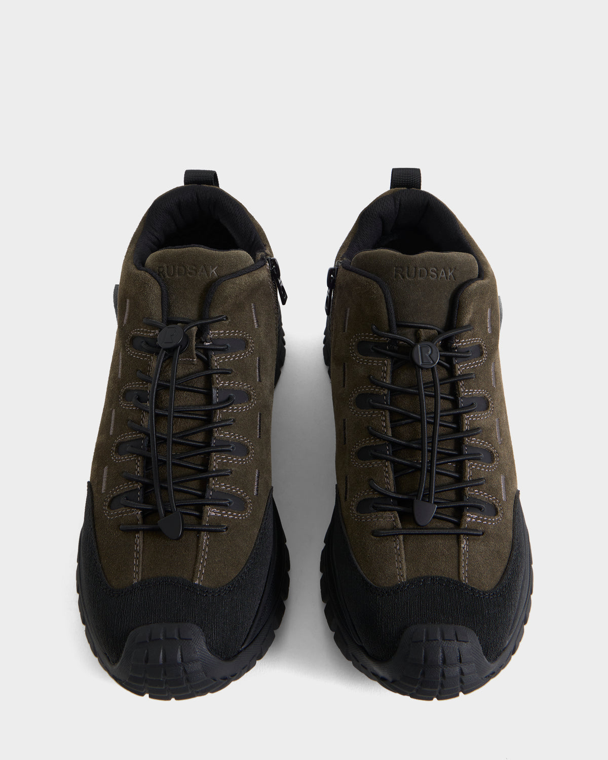 A pair of Rudsak MAX S - 6226505 Olive men’s sneakers in olive green and black, featuring thick rugged soles, dark laces, trail-inspired detailing, and suede accents, shown from above on a plain light background.