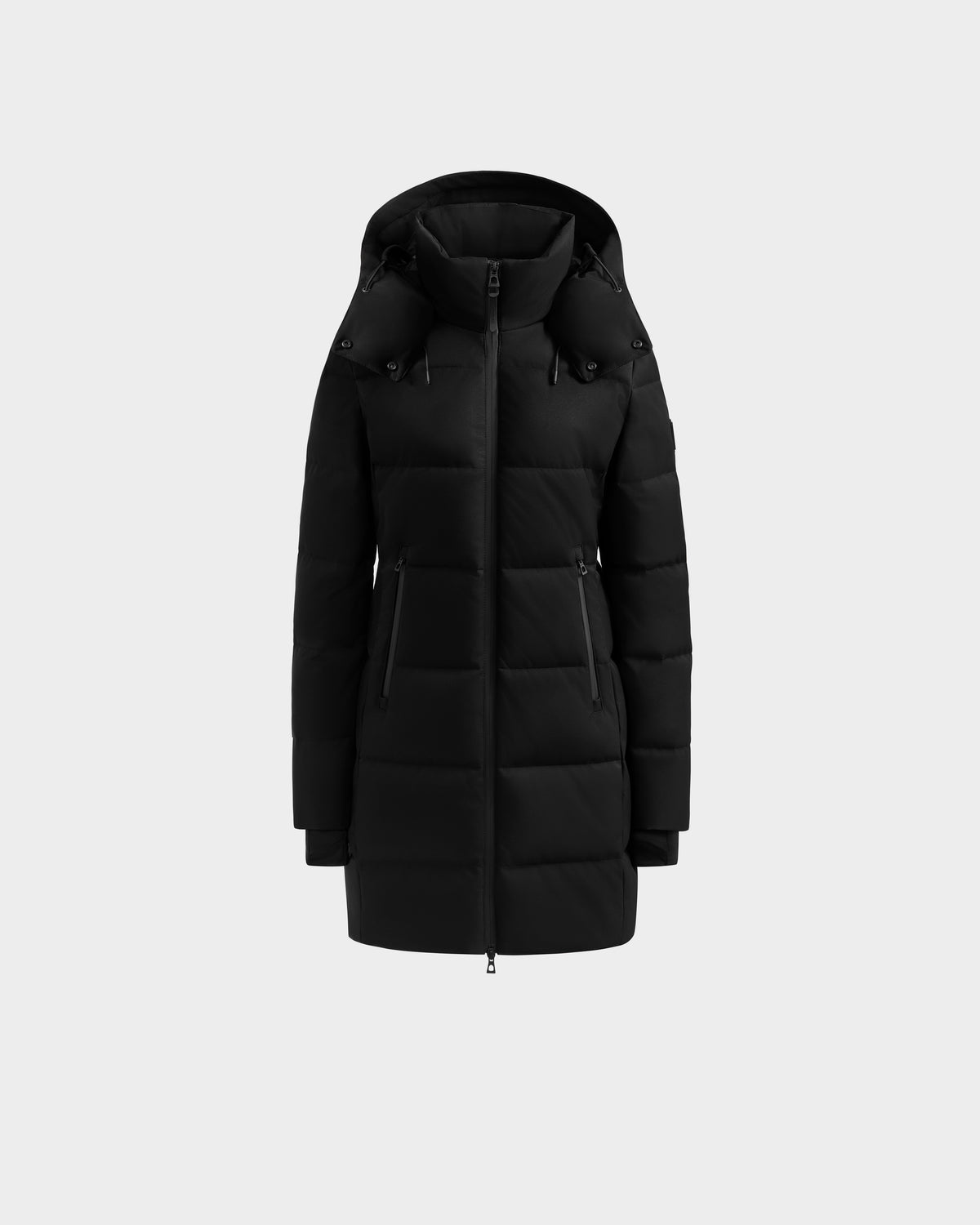 The Rudsak MIRIAM MW - L125604 Black is a knee-length women’s down puffer jacket with RDS-certified fill, front zipper, two zippered side pockets, and long sleeves, shown on a plain light gray background.